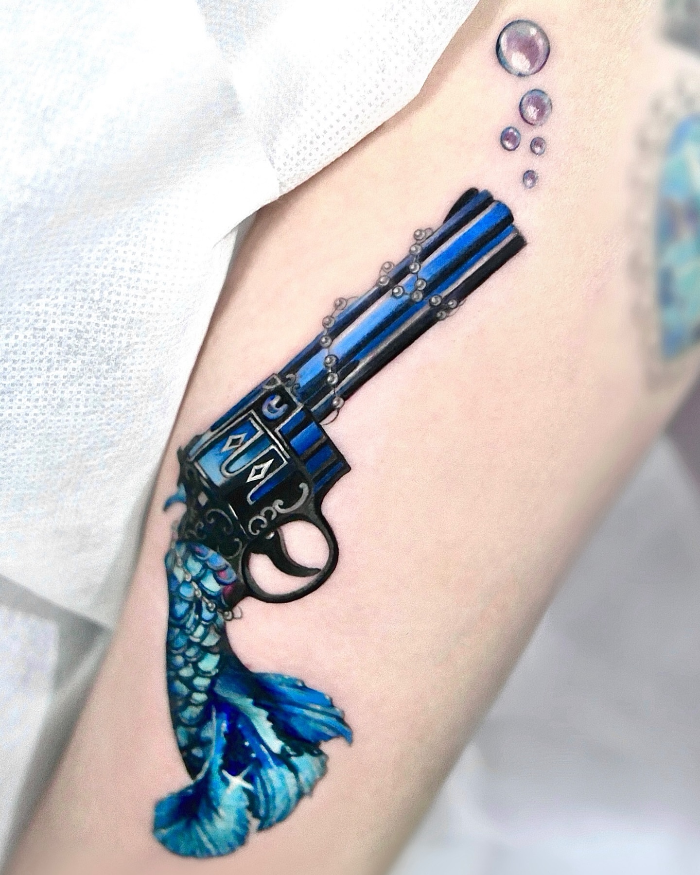 Gun with mermaid tail realism tattoo on the forearm by Cyber sigil & ornamental tattoo π₯