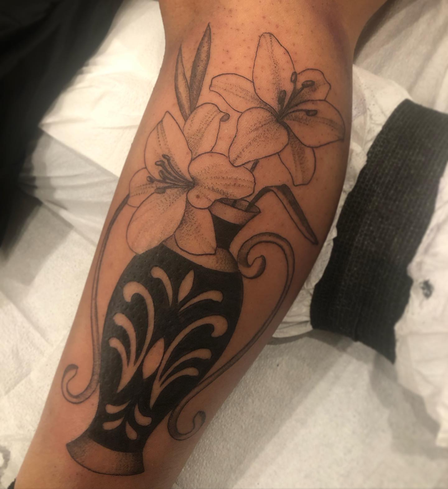 Lilies in vase black and grey tattoo on the forearm by Cassandra Colleen