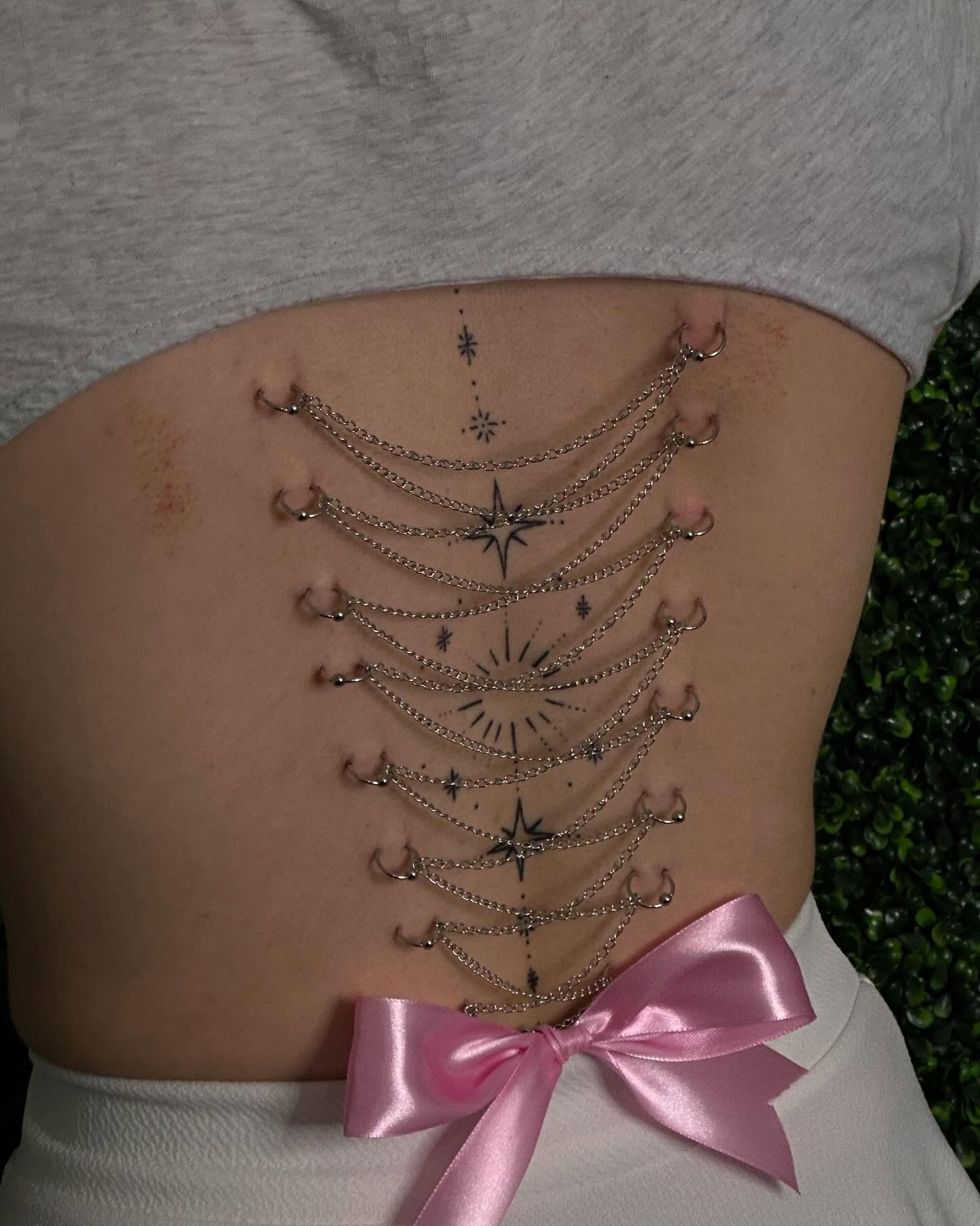 Corset lacing geometric tattoo on the torso by Zoie Stiles