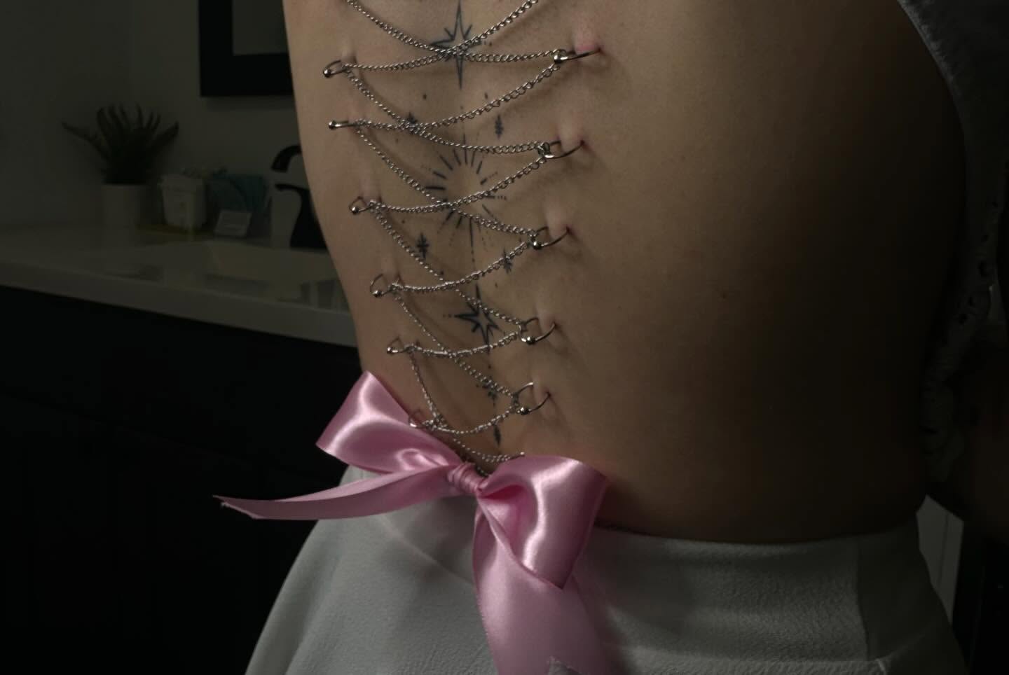 Corset black and grey tattoo on the torso by Zoie Stiles