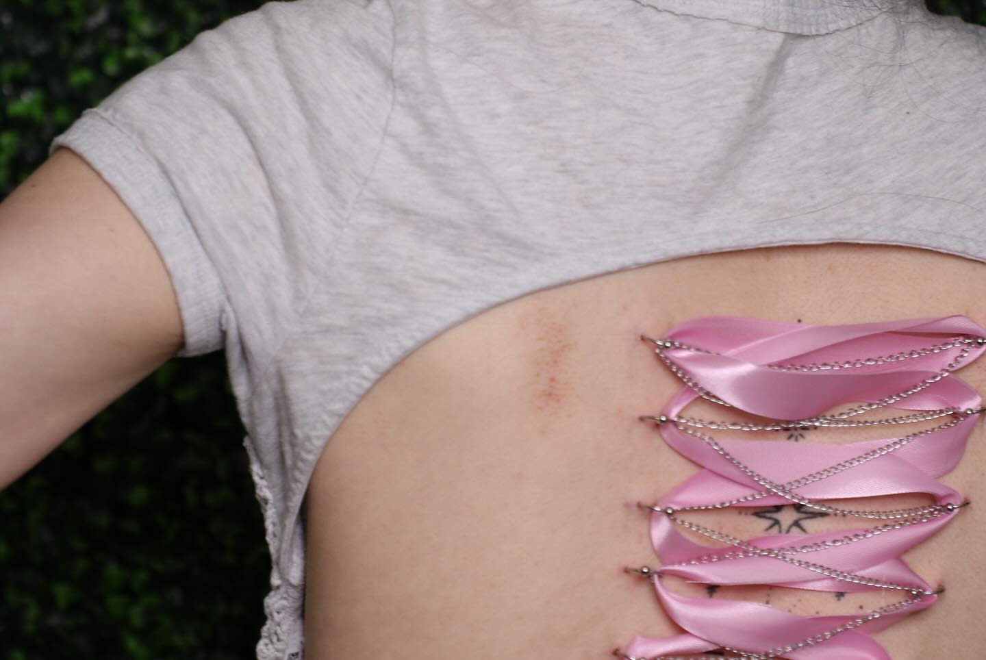 Pink feather geometric tattoo on the torso by Zoie Stiles