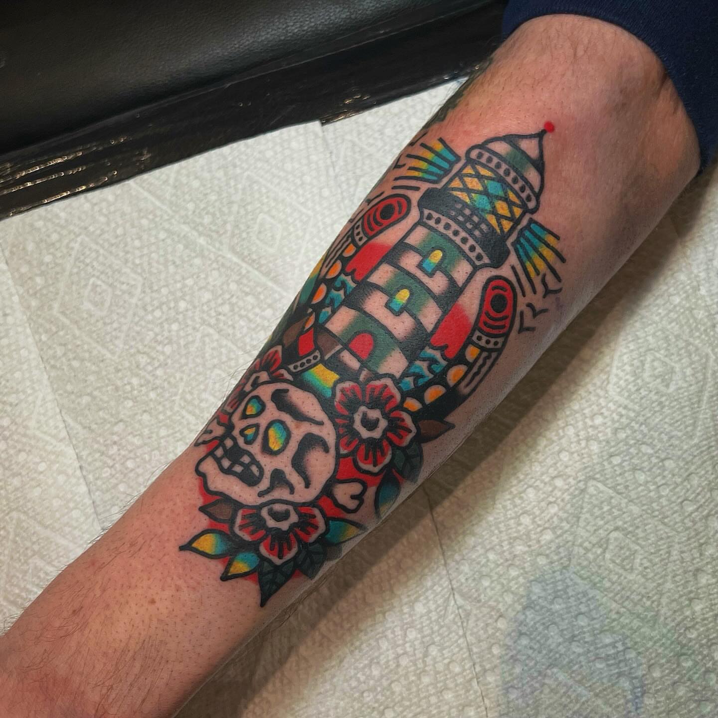 Sugar skull and lighthouse American traditional tattoo on the forearm by Benjamin Ward