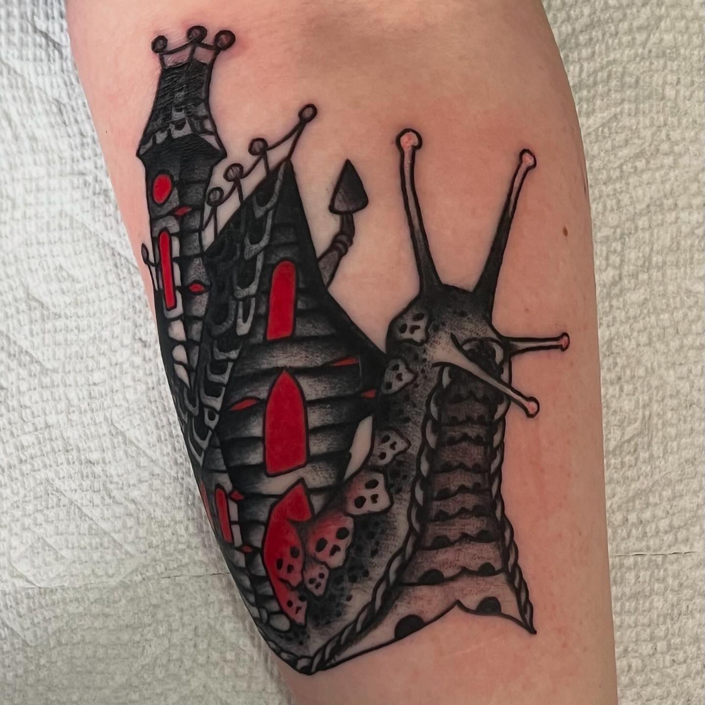 Snail black and grey tattoo on the forearm by Matt E.