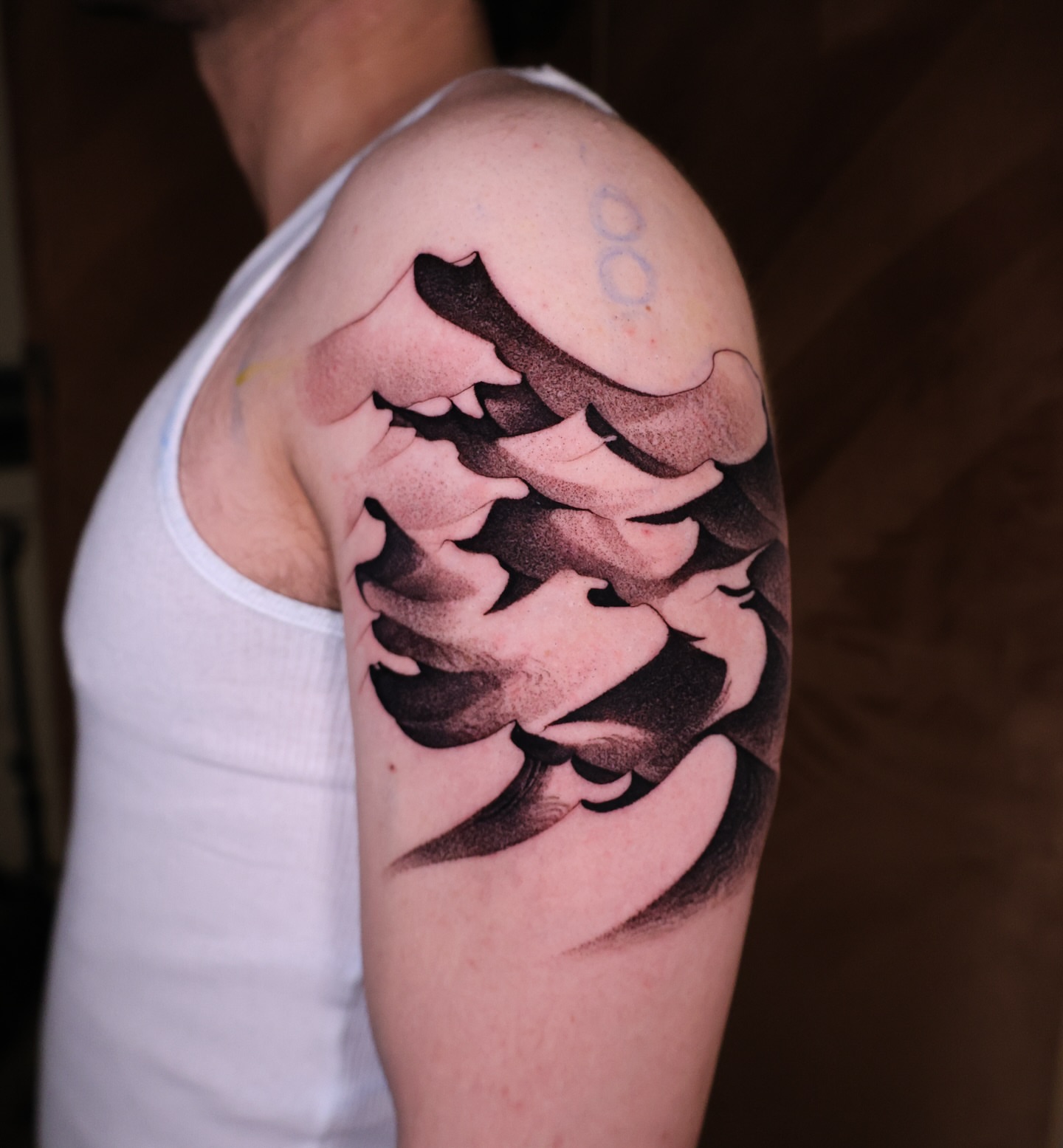 Wave black and grey tattoo on the upper arm by Strokin Konstantin