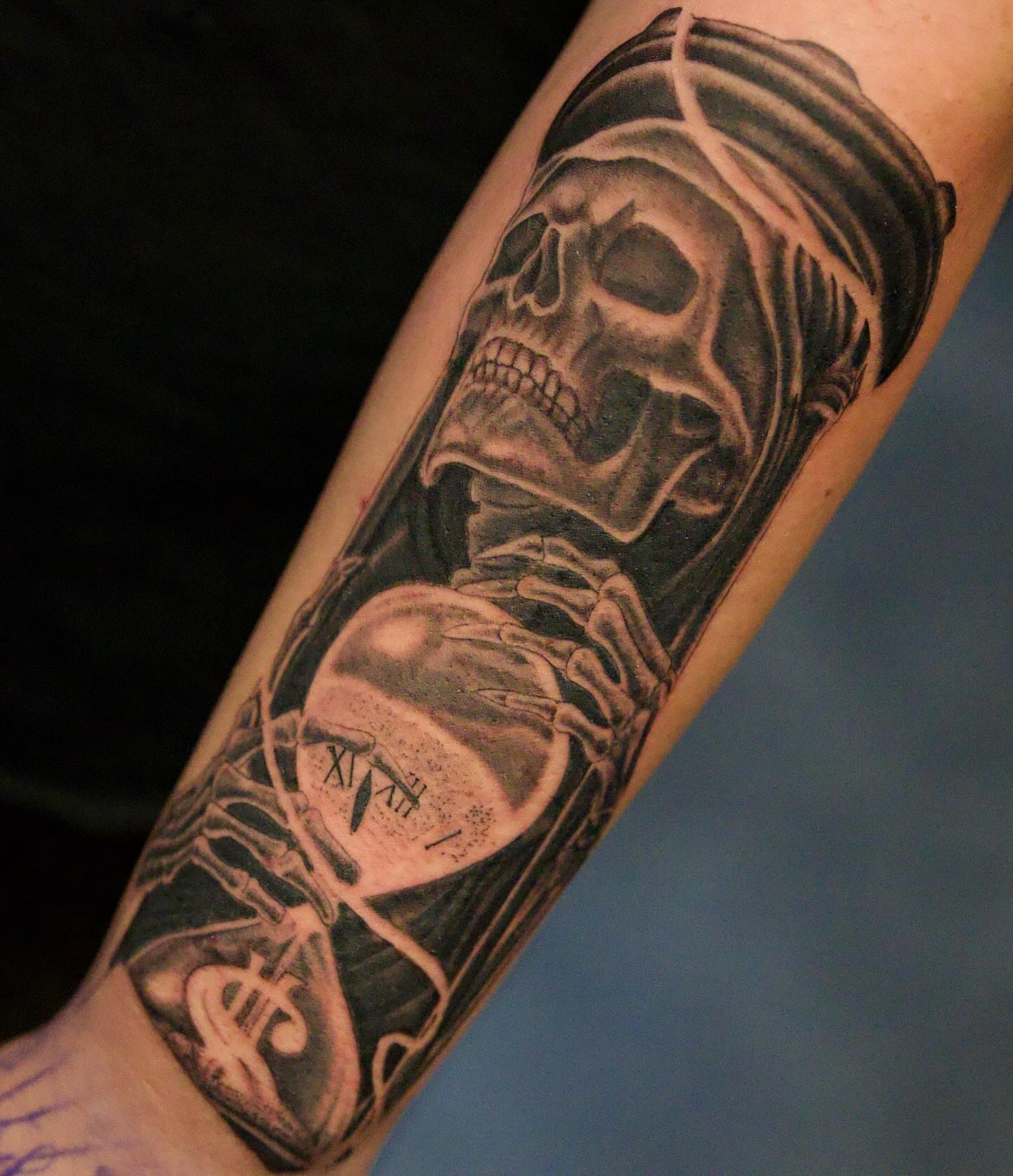 Skull with hourglass realism tattoo on the forearm by Chris Lochbihler