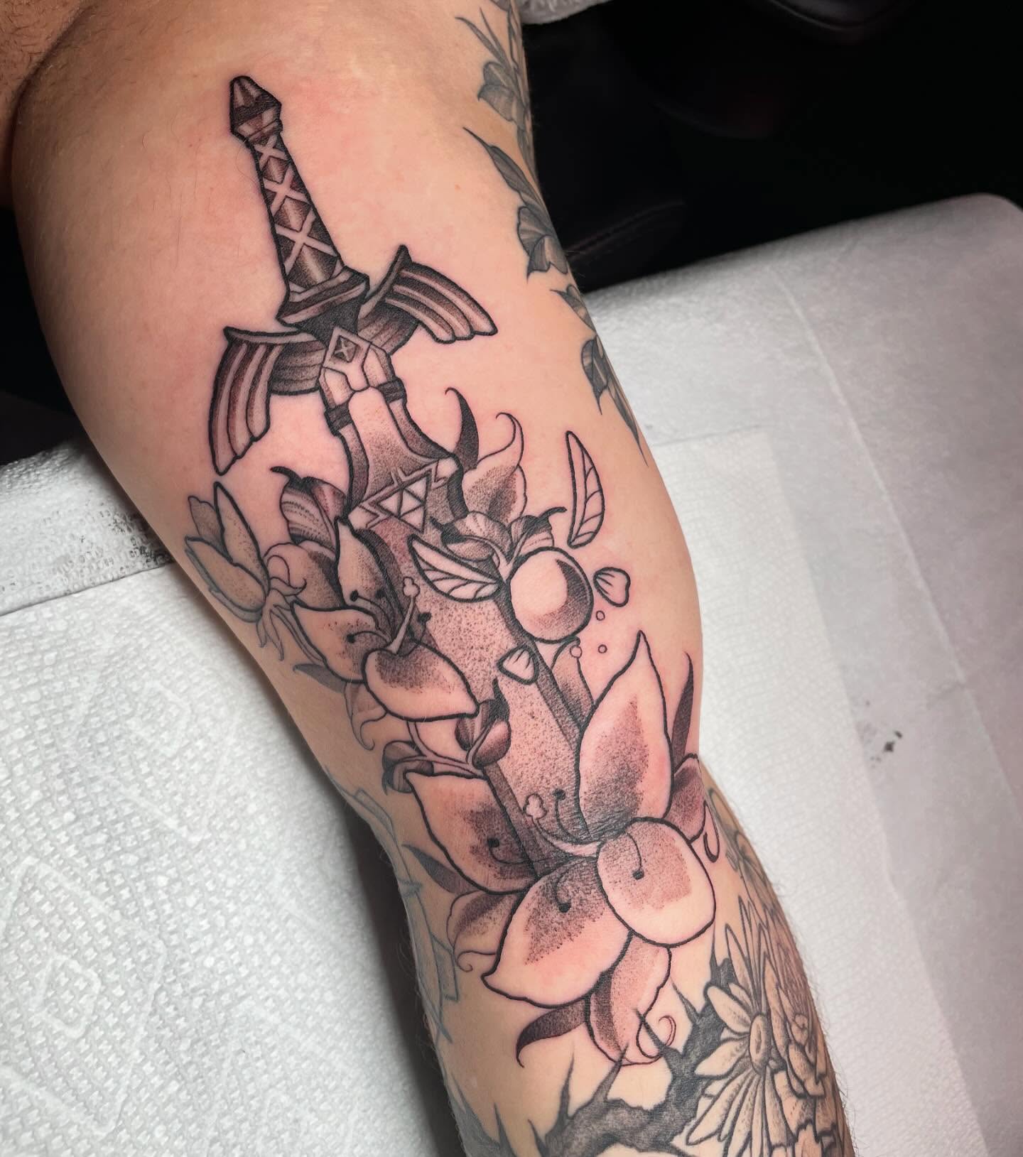 Sword and flowers dotwork tattoo on the forearm by Tayler Beetison