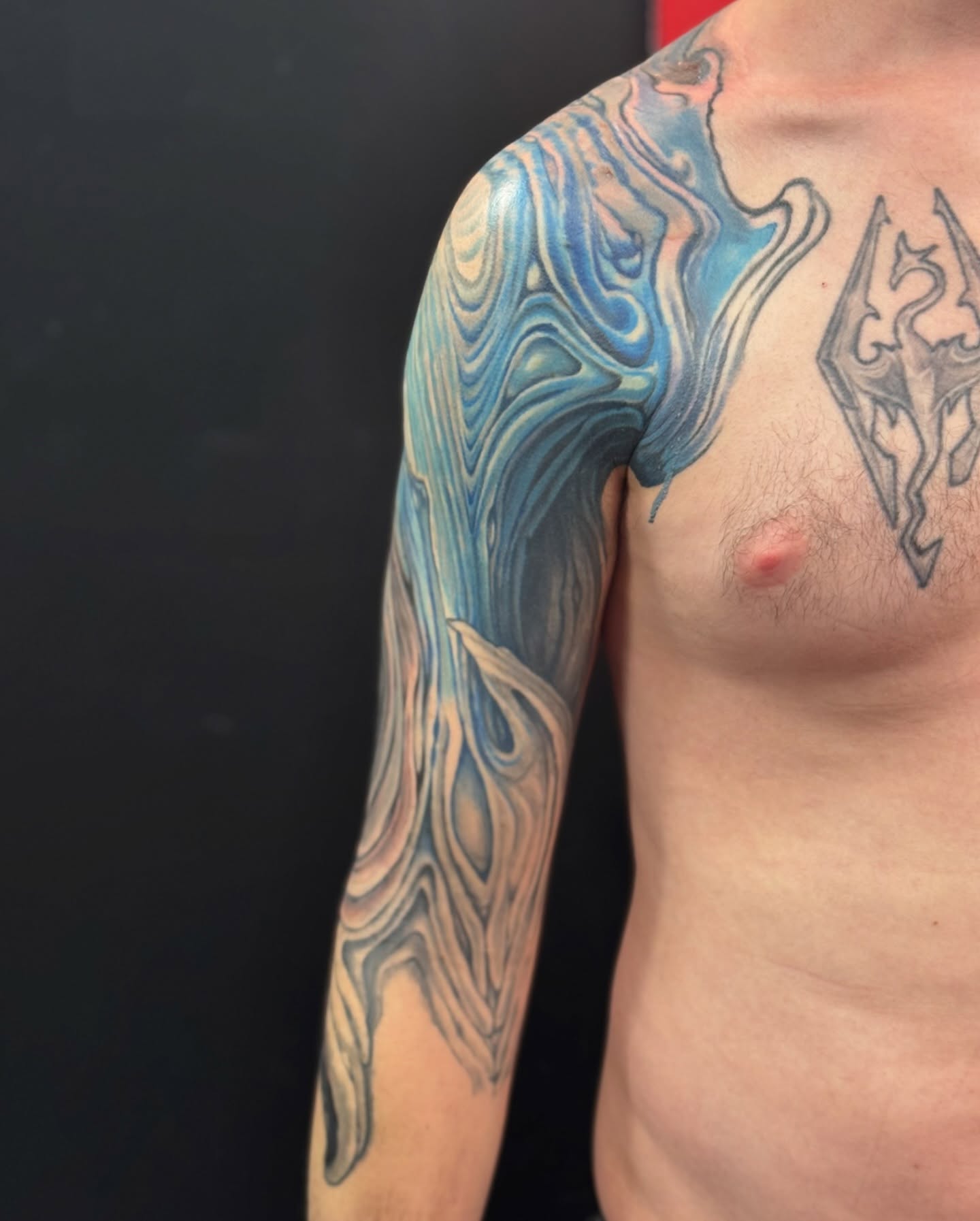 Water new school tattoo on the upper arm by Jordan Rookus