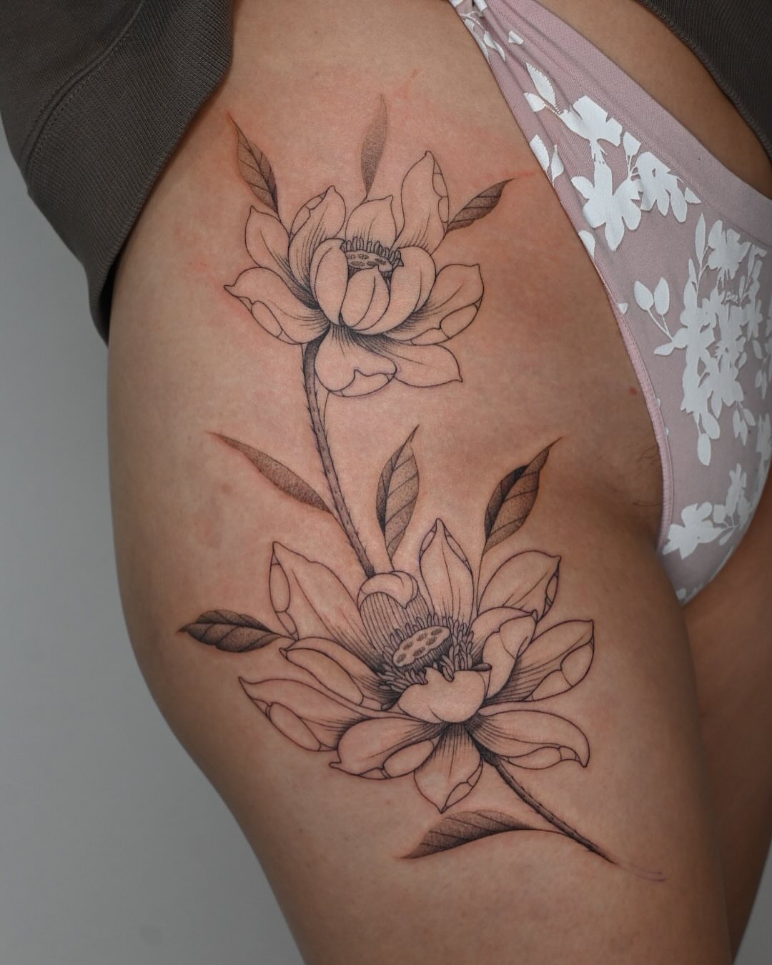 Lotus flowers black and grey tattoo on the thigh by Simba Nguyen