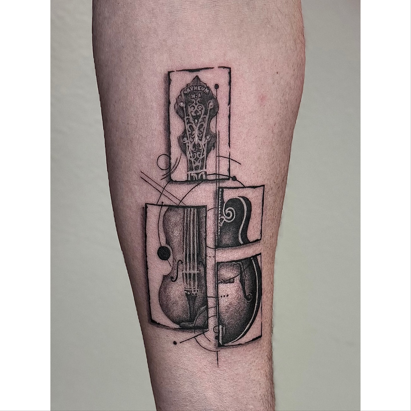Violin geometric tattoo on the forearm by Miro Ink Tattoo