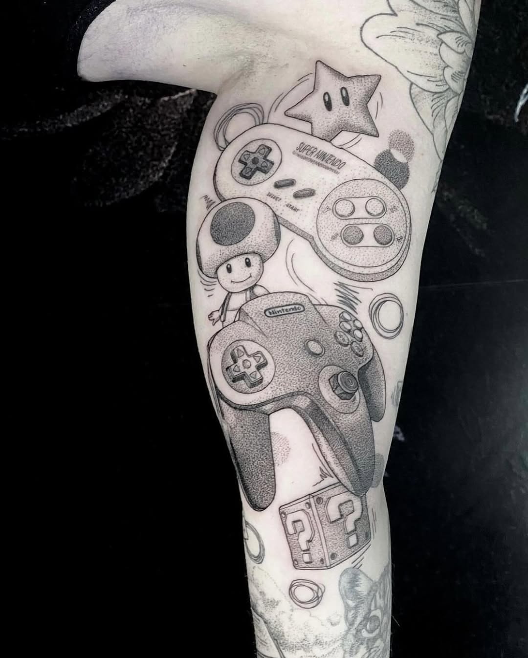 Video game controller and characters dotwork tattoo on the forearm by Rowan Starr