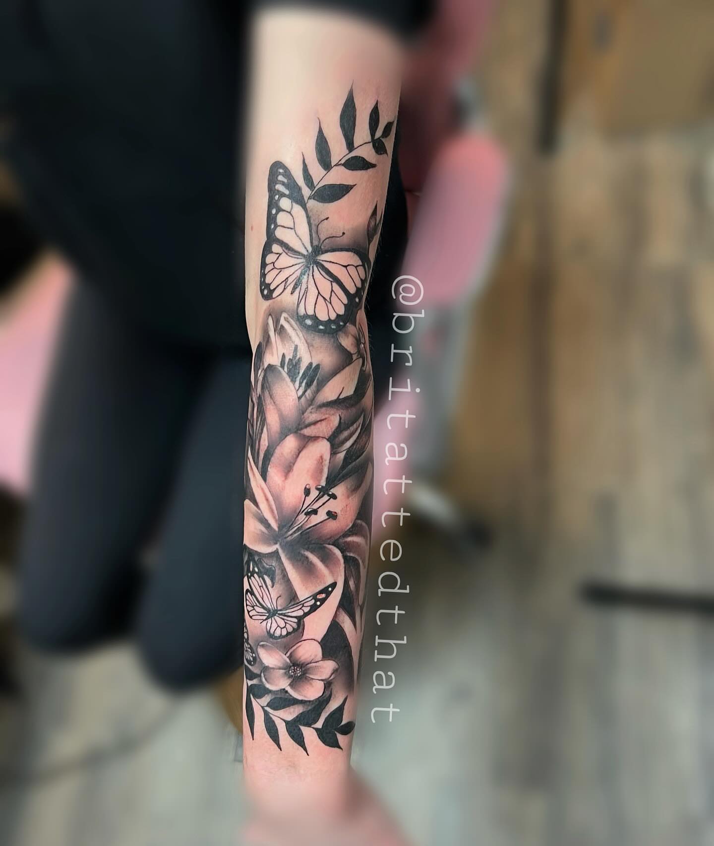 Butterfly and flowers black and grey tattoo on the forearm by Bri Tatted That