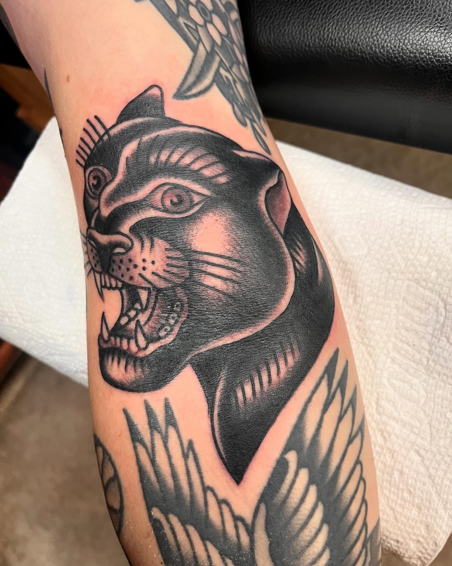 Panther American traditional tattoo on the forearm by ๐๐ฎ๐ฌ๐ญ๐ข๐ง ๐๐จ๐ฐ๐๐ซ๐, Oakland, California