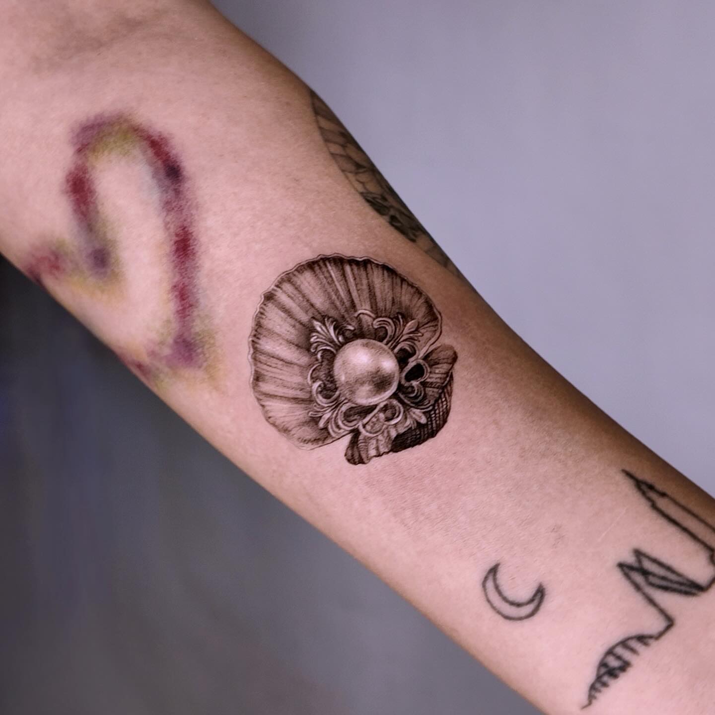 Nautilus shell black and grey tattoo on the forearm by Gabriel