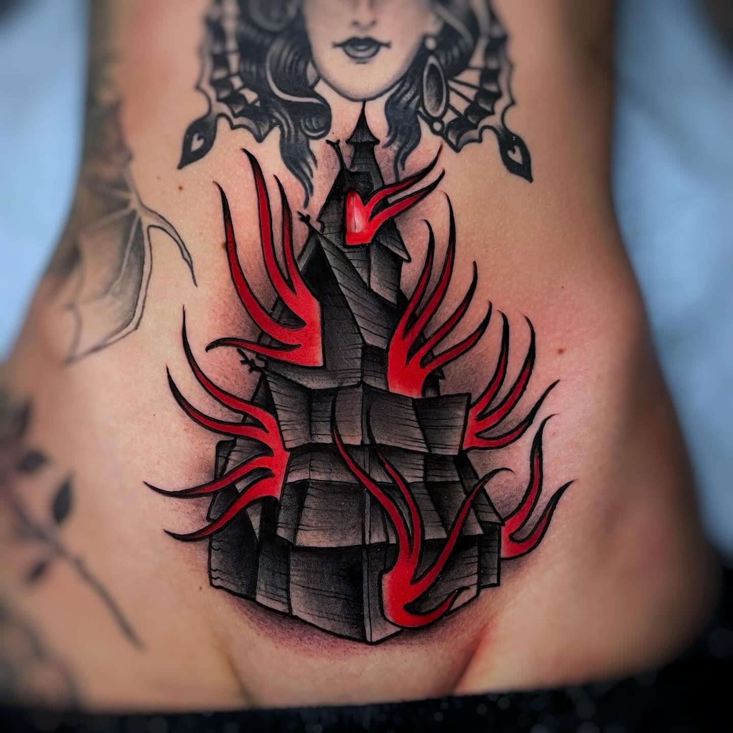 Castle with flames dark realism tattoo on the torso by Ick Abrams