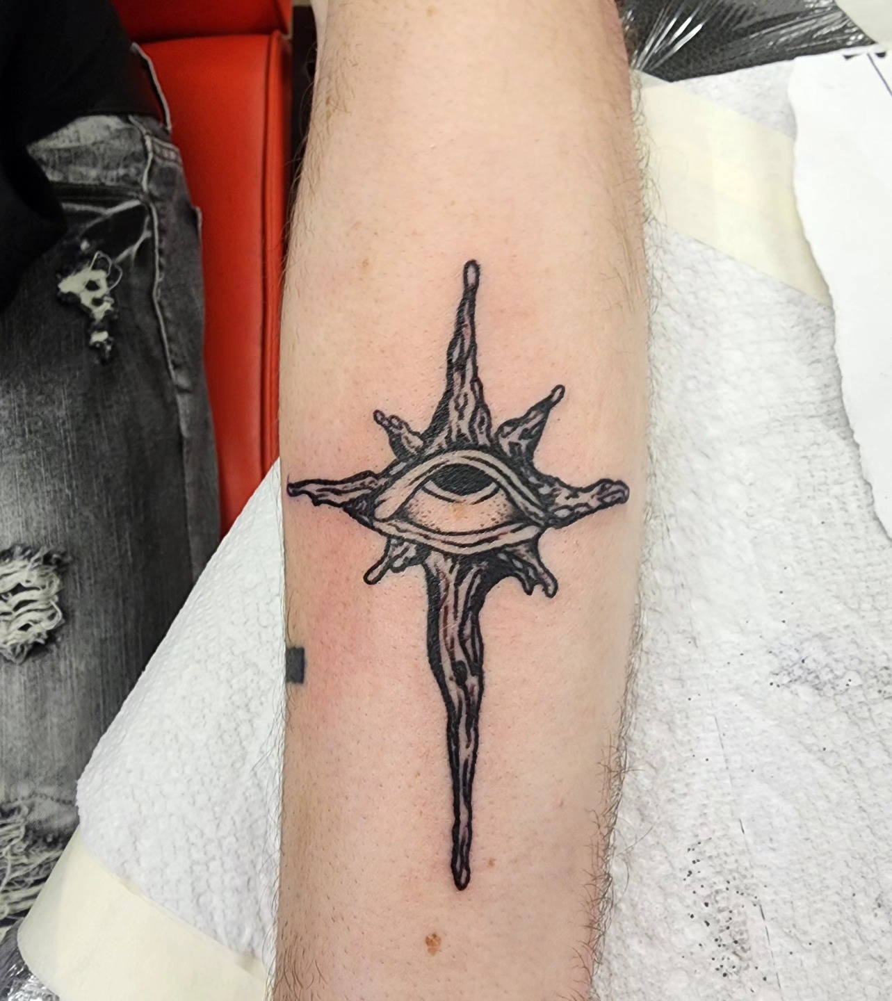 Eye with cross black and grey tattoo on the forearm by @thedevilspaintbrush_