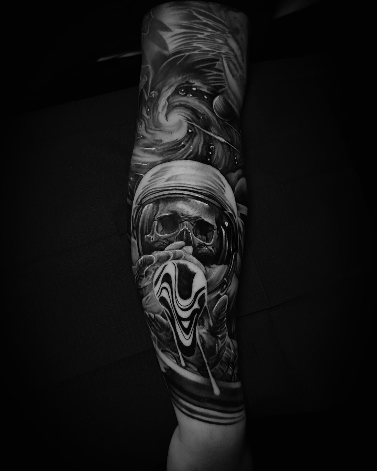 Skull with swirling background realism tattoo on the forearm by Nick Stratt