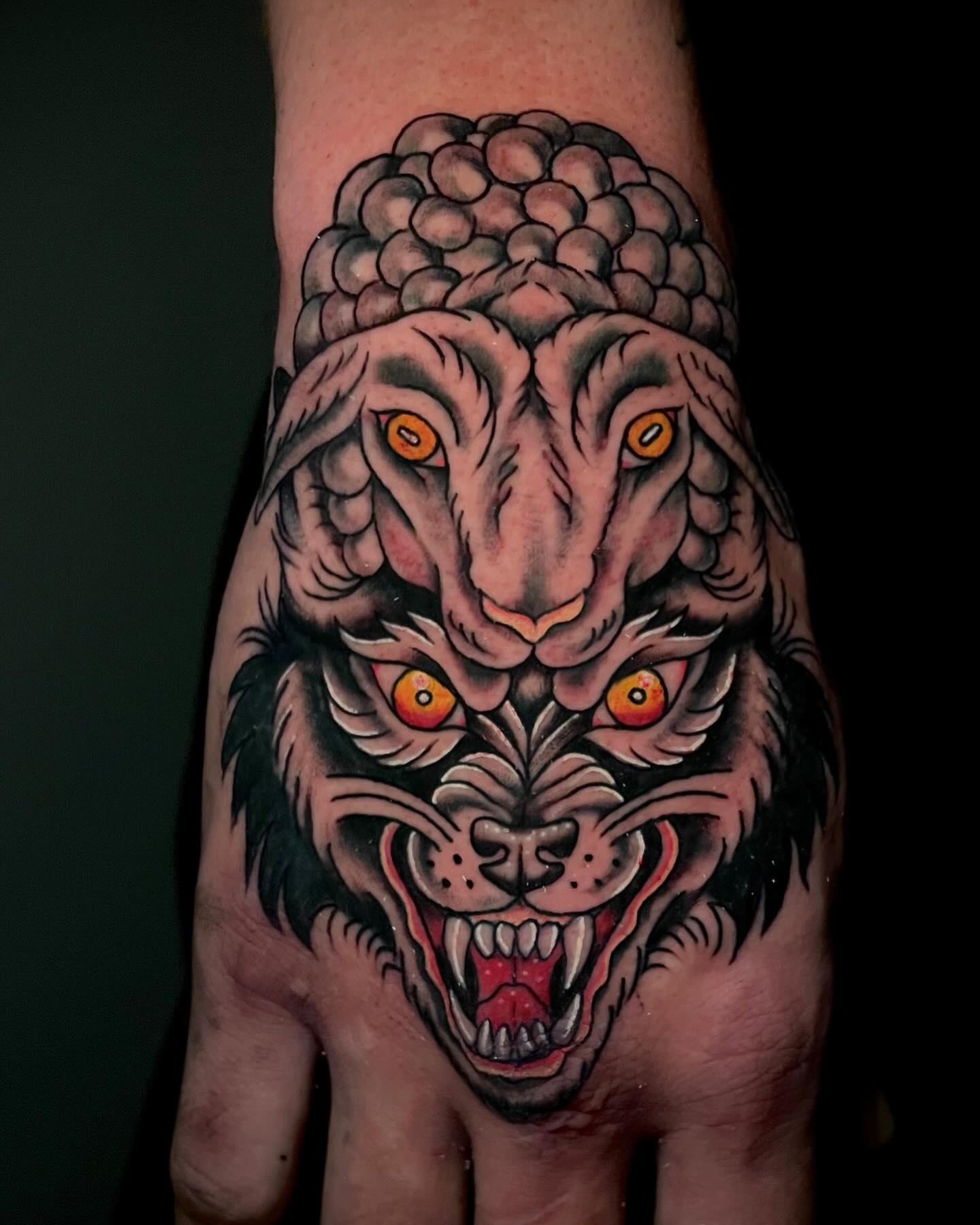 Ram and wolf heads American traditional tattoo on the hand by Madison ‘Maddog’ Stewart