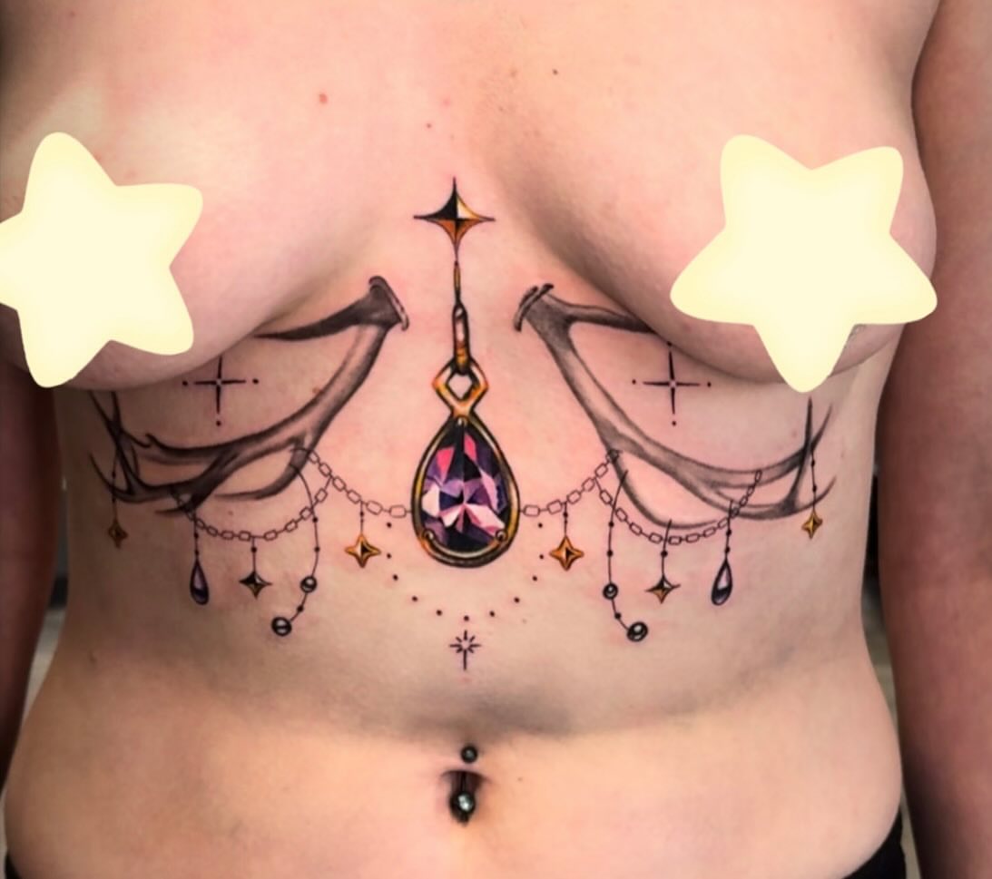 Antlers and gem geometric tattoo on the chest by Amanda Lineweaver