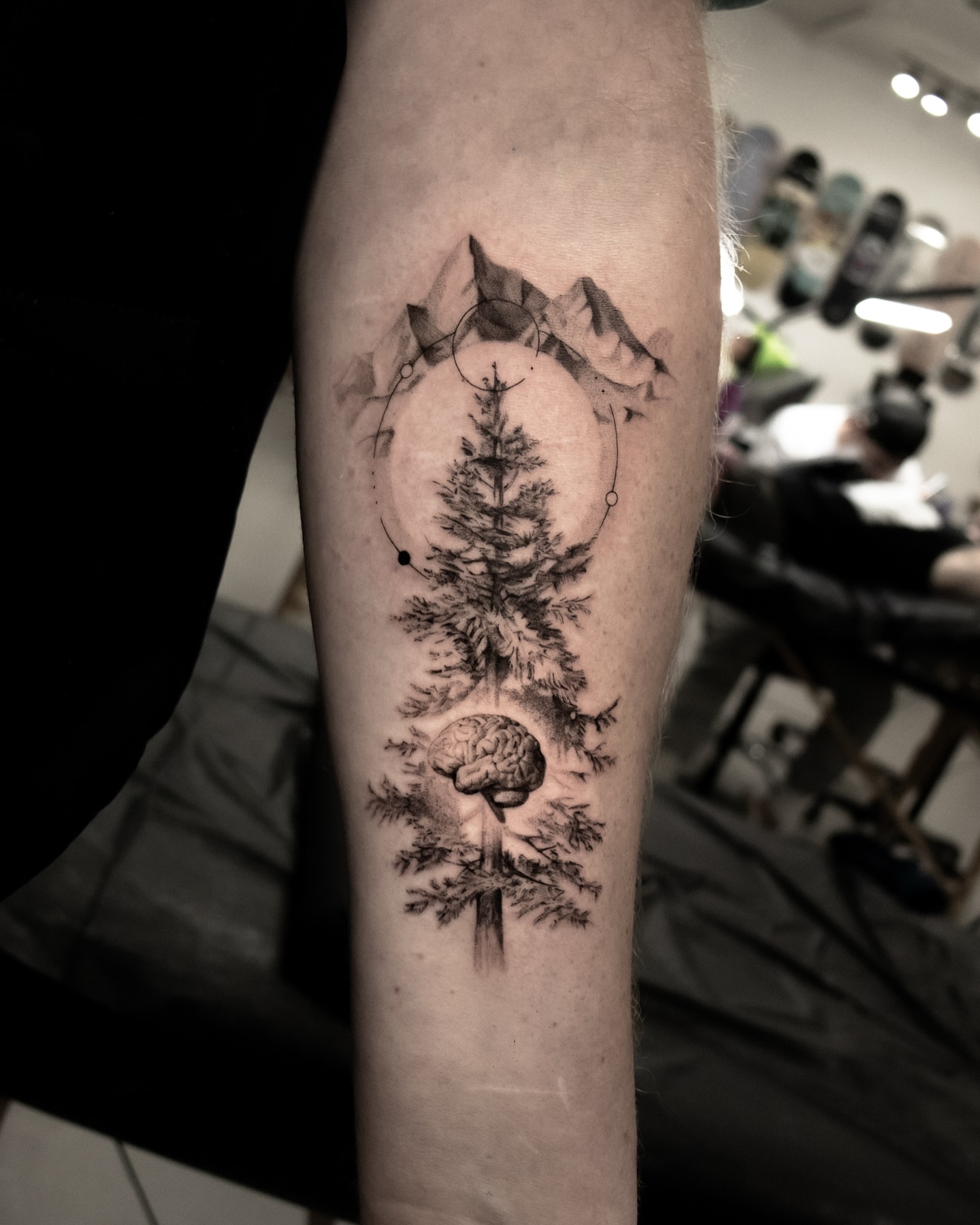 Pine tree and brain realism tattoo on the forearm by Riley K Turner