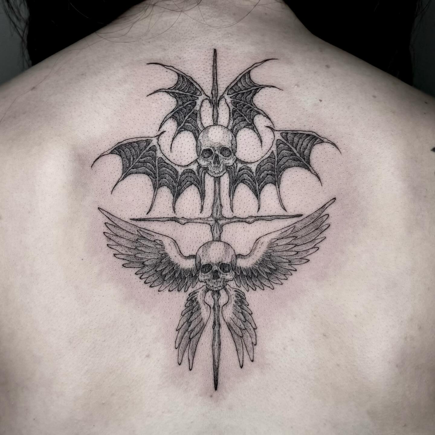 Bat wings and skulls dotwork tattoo on the back by taline