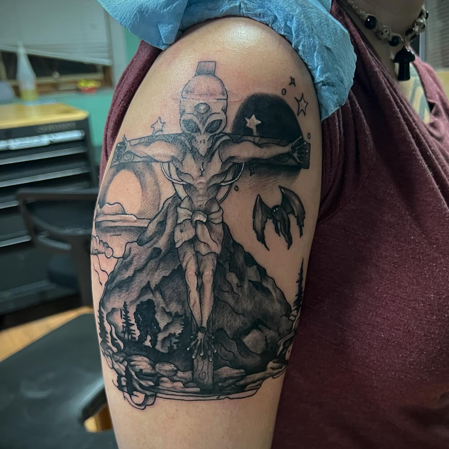 Astronaut crucifixion realism tattoo on the shoulder by Katie Sayre