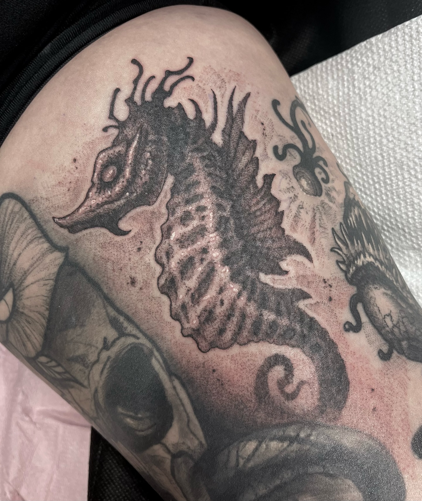 Seahorse black and grey tattoo on the thigh by Jamie