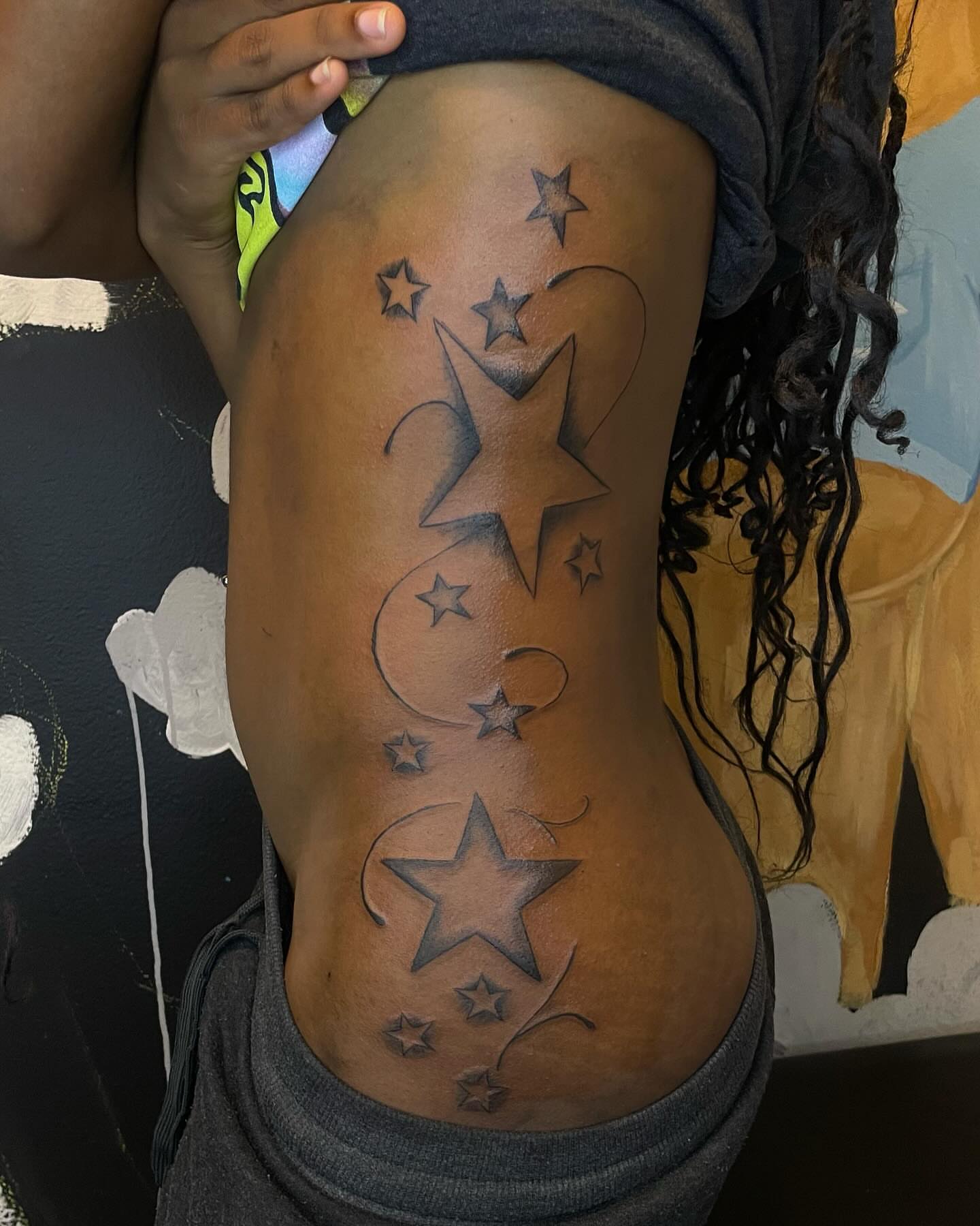 Stars black and grey tattoo on the thigh by Dinero Inks