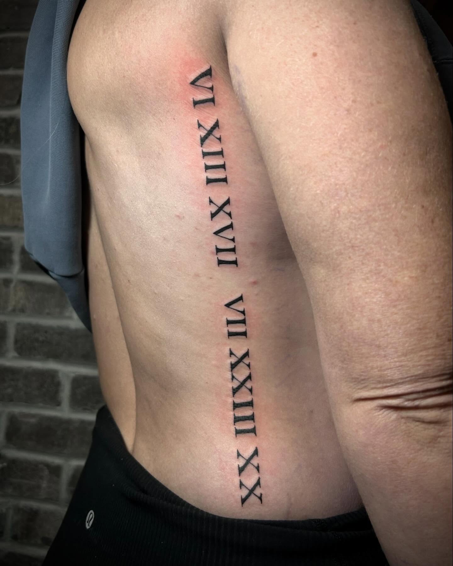 Roman numerals lettering script tattoo on the ribs by Chloe