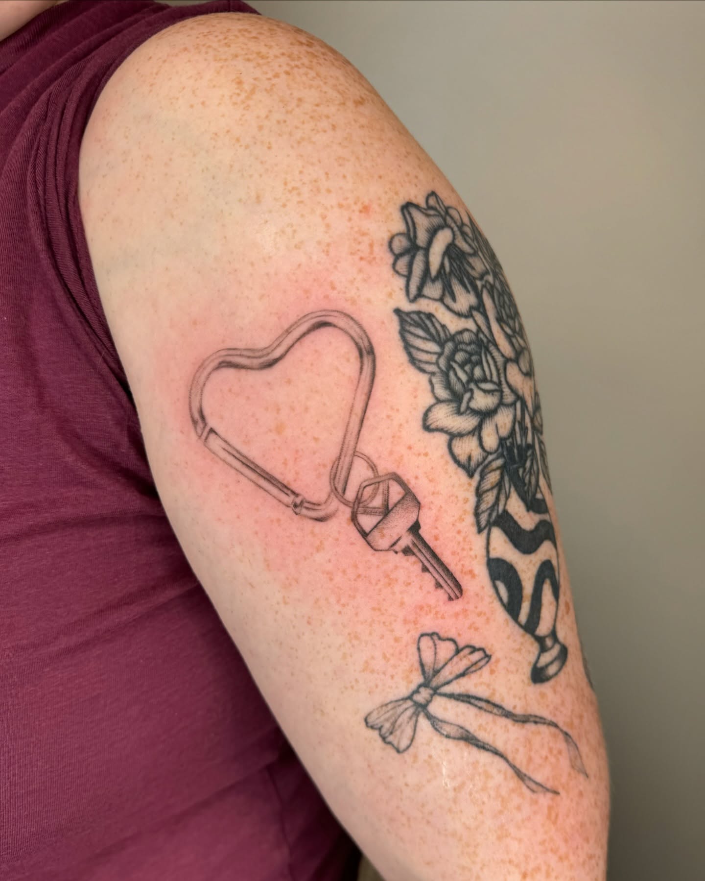 Heart-shaped stethoscope black and grey tattoo on the forearm by Mariana; Fine Line Tattoo Artist