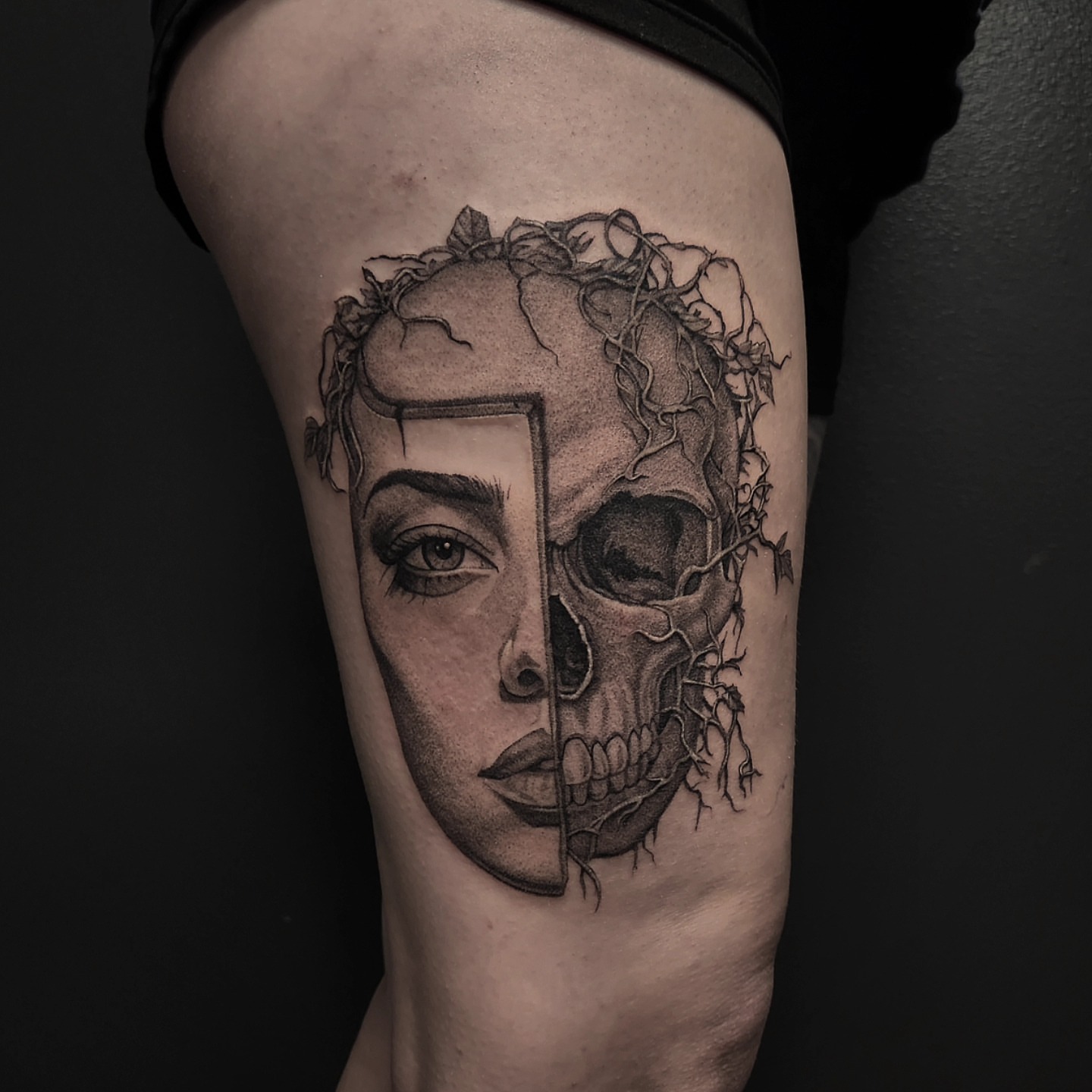 Skull and woman's face dotwork tattoo on the thigh by Kyle Joseph [tattoo artist]