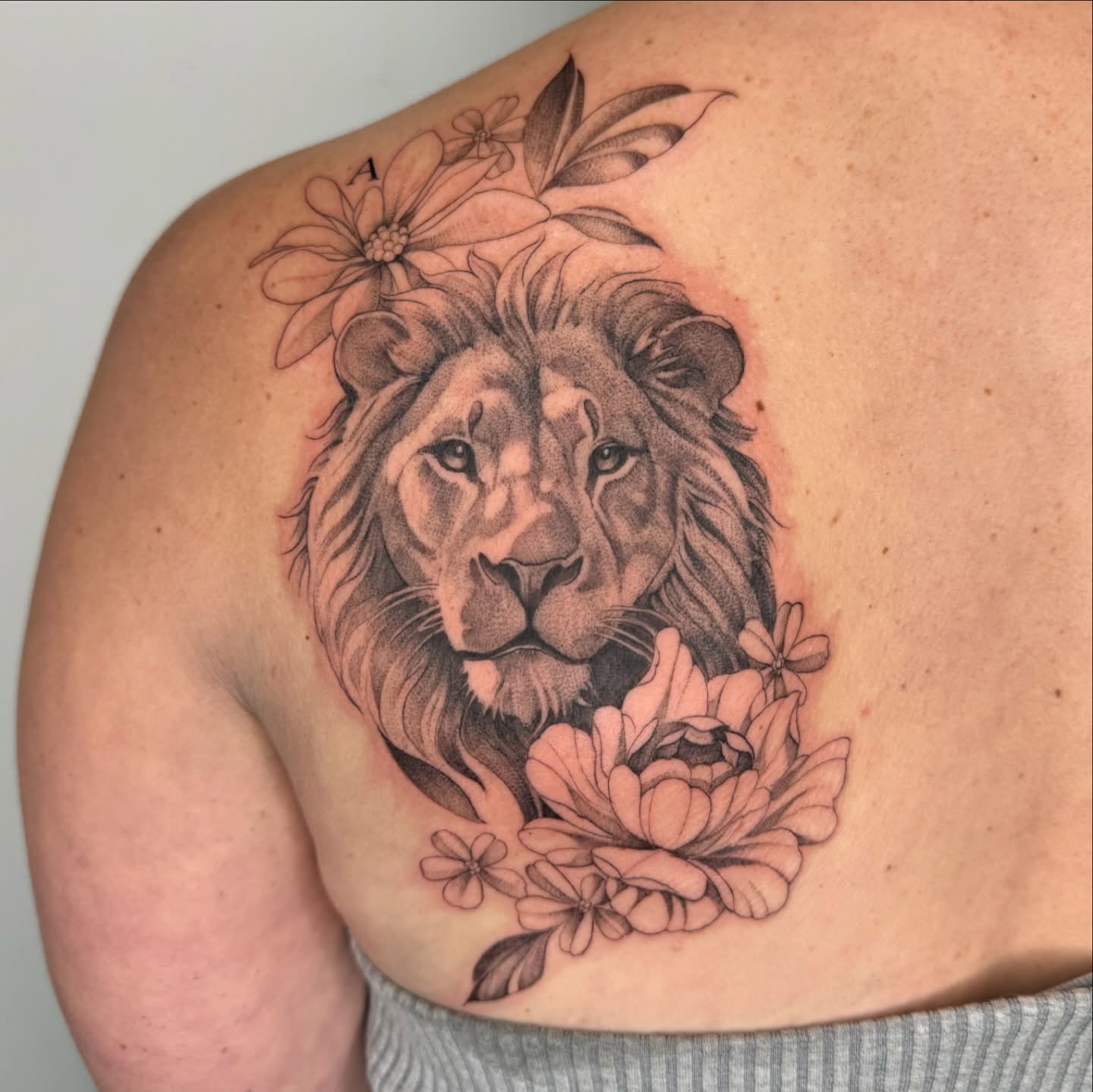 Lion with floral crown dotwork tattoo on the shoulder by Alyssa . Villela