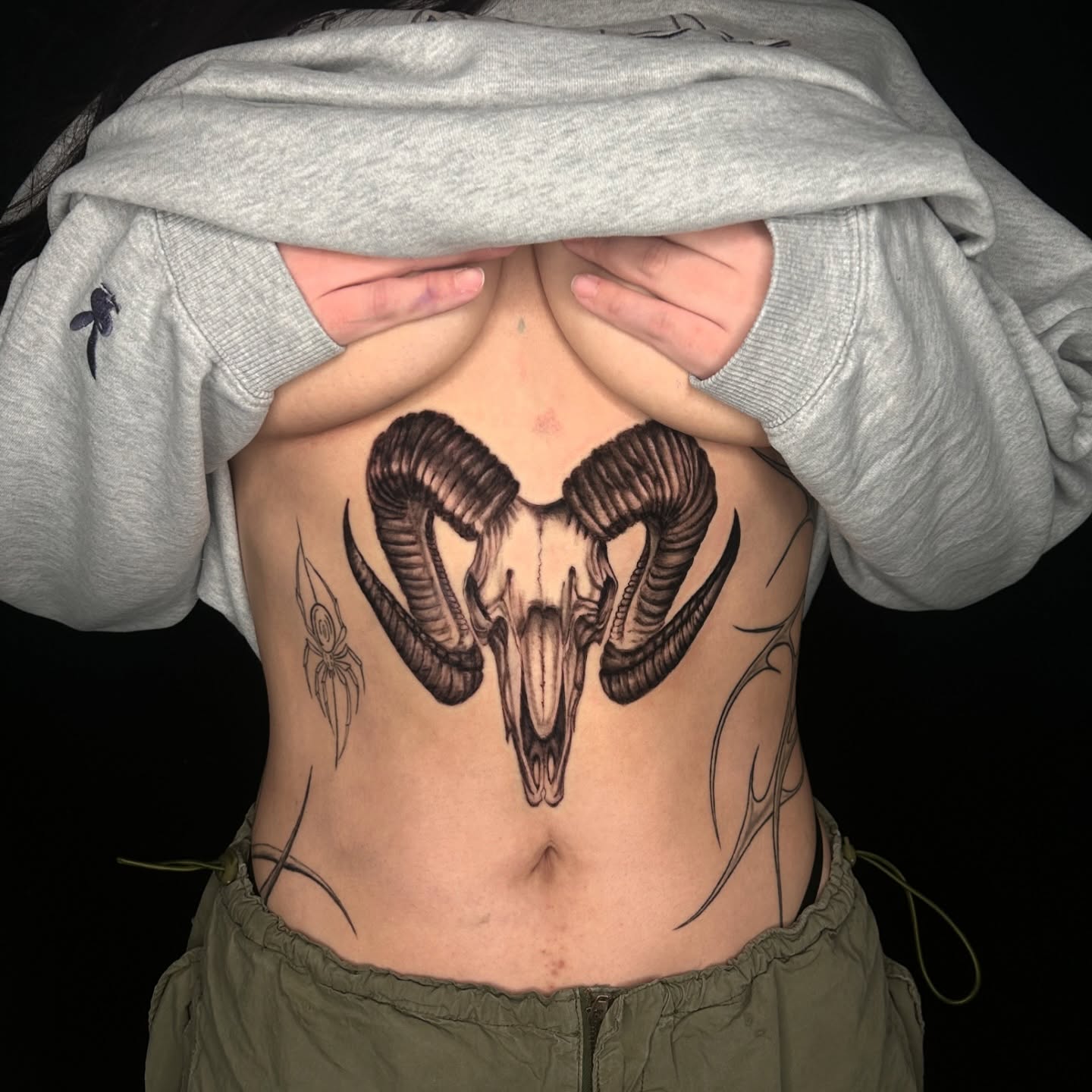 Ram skull black and grey tattoo on the ribs by Haley