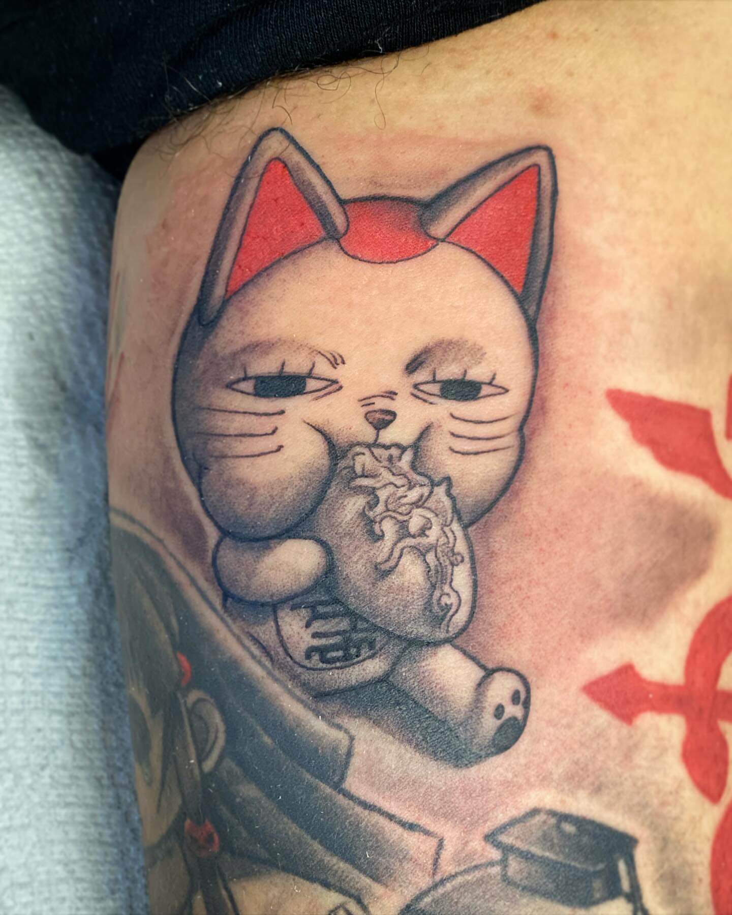 Cat eating noodles realism tattoo on the upper arm by Seth Mullin, Hemet, California