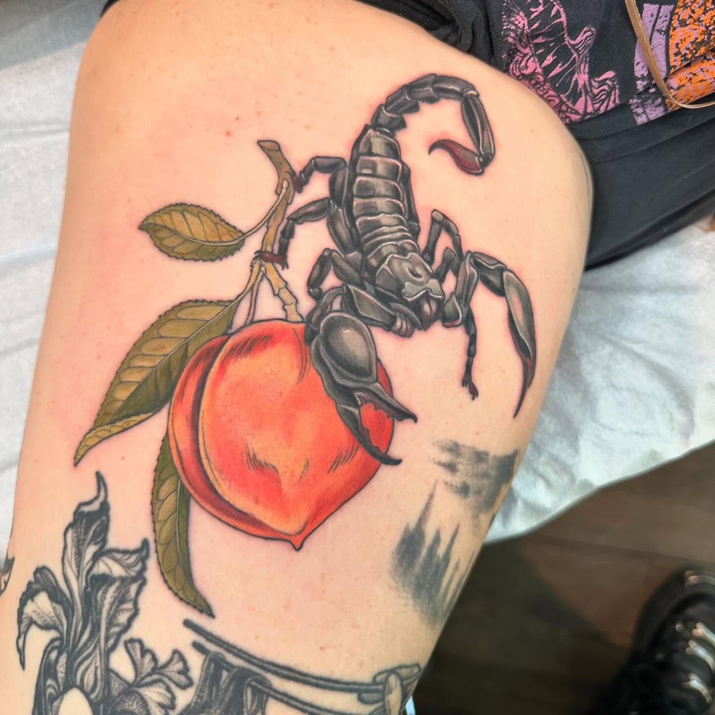 Scorpion and peach realism tattoo on the thigh by Cassidy Depew, Seattle, Washington