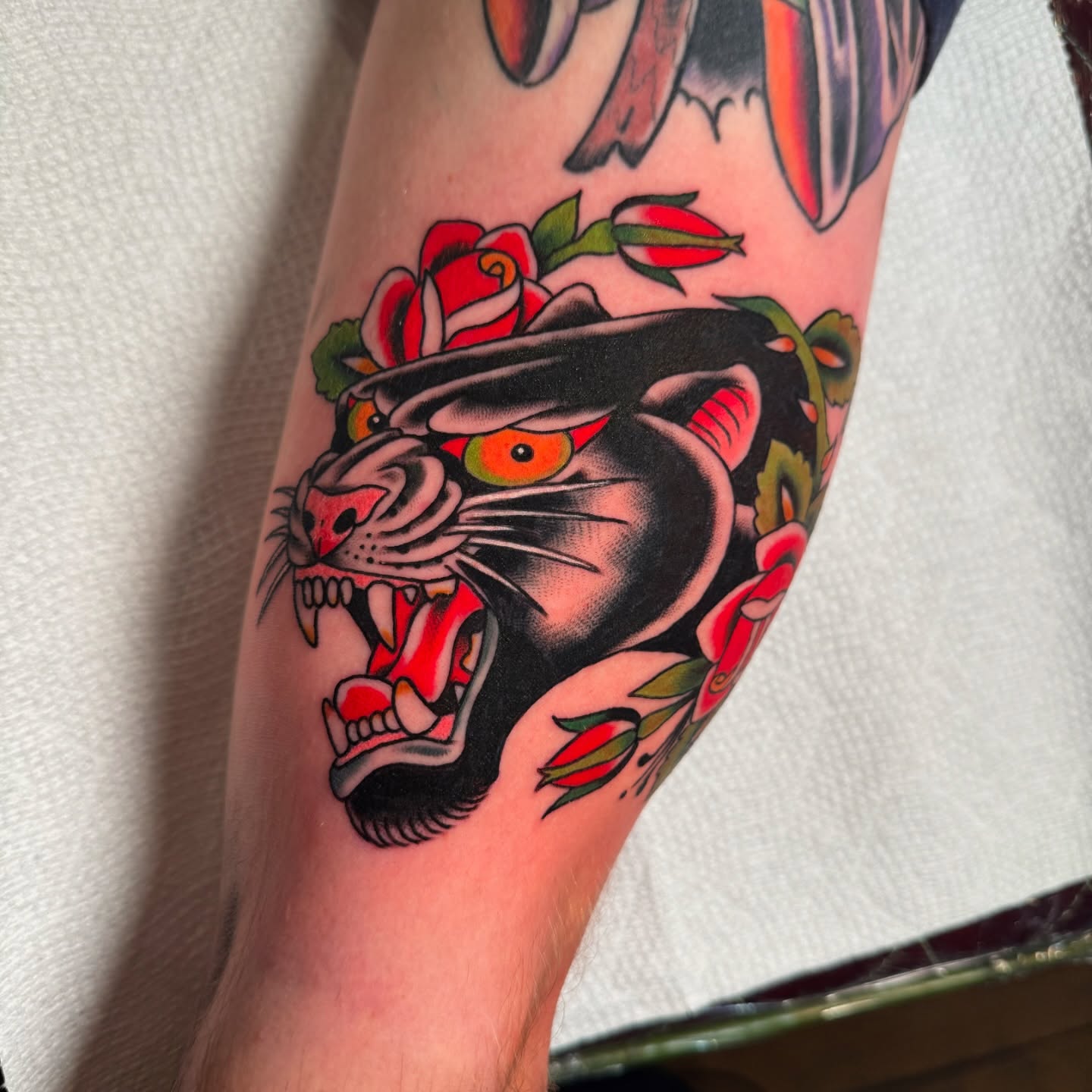 Panther with roses American traditional tattoo on the forearm by πππ’π―π’π¨ πππΆπ©π¬π―π, Manchester, New Hampshire