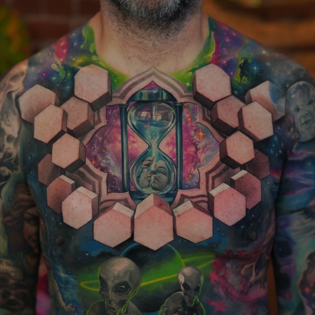 Hourglass and hexagons geometric tattoo on the chest by Jesse Rix