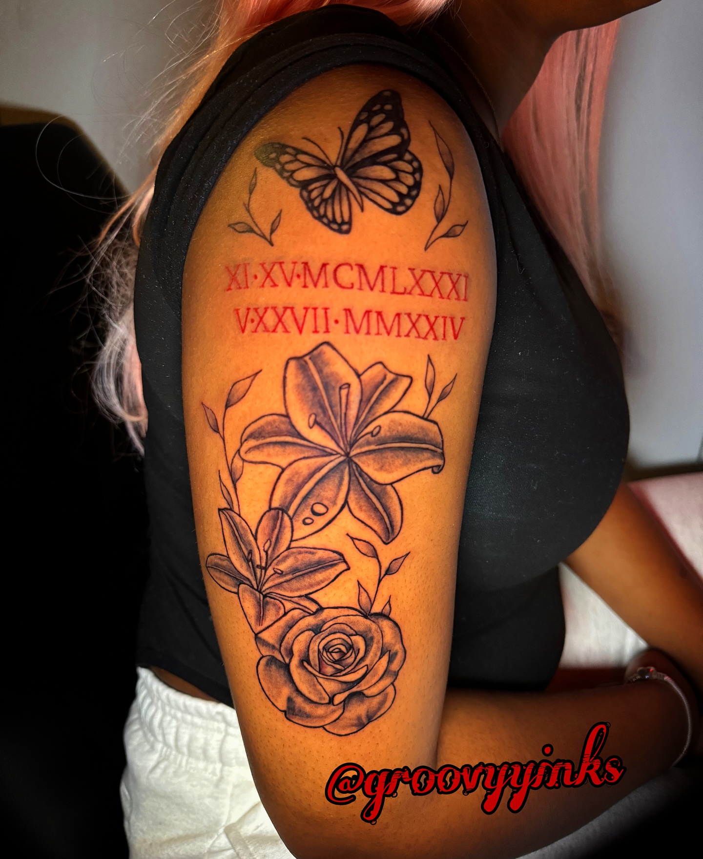 Butterfly, lily, rose, Roman numerals black and grey tattoo on the forearm by groovyyinkss