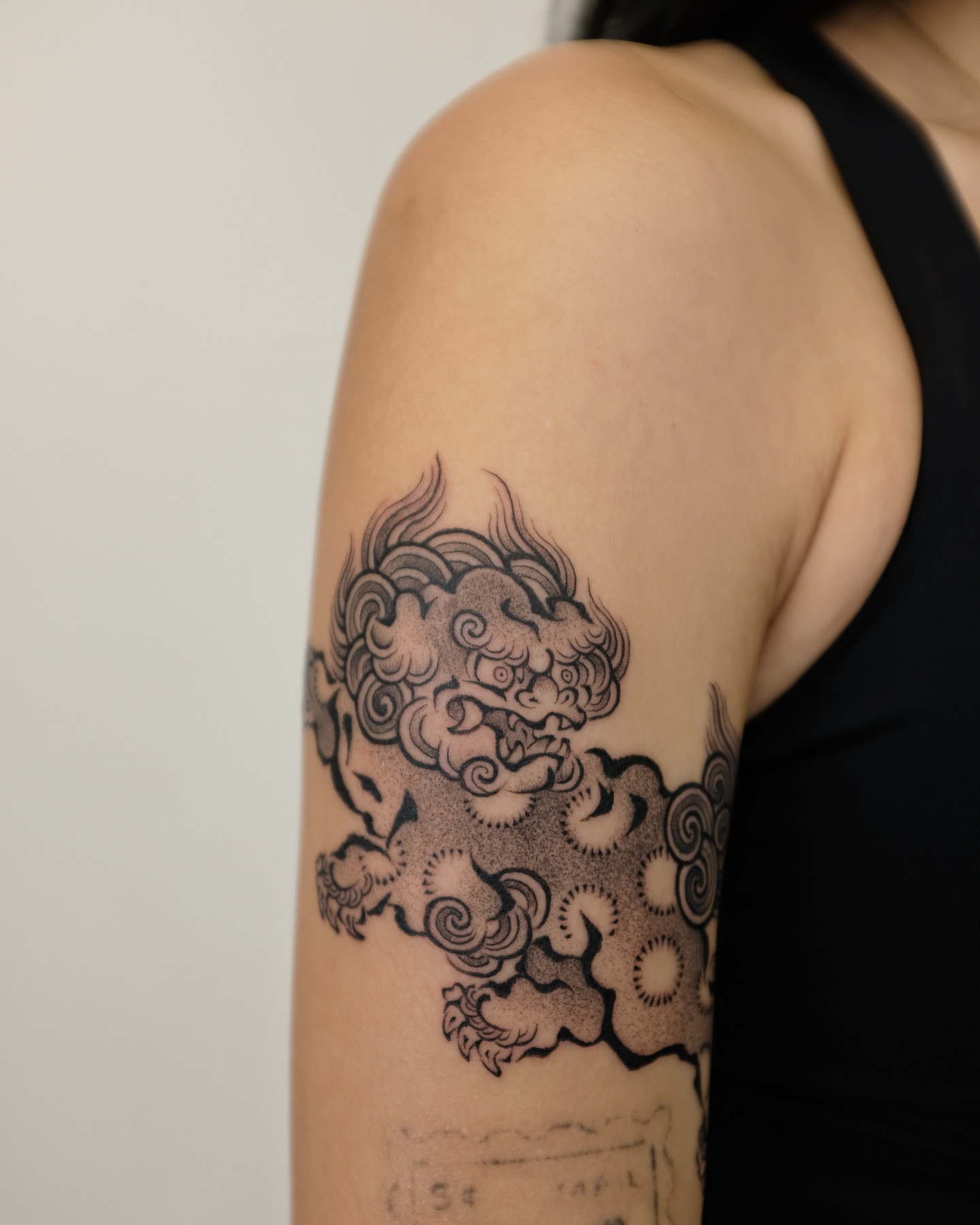 Cloud dragon black and grey tattoo on the upper arm by Xiao Lun