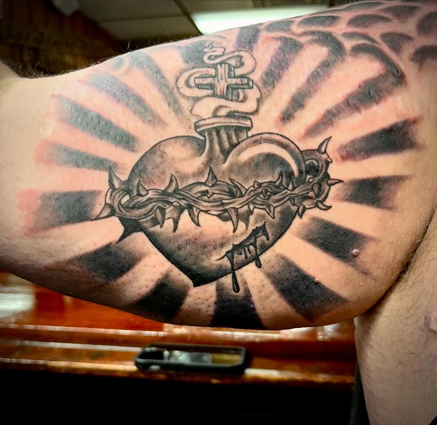 Heart with crown of thorns black and grey tattoo on the forearm by Kenny Buck