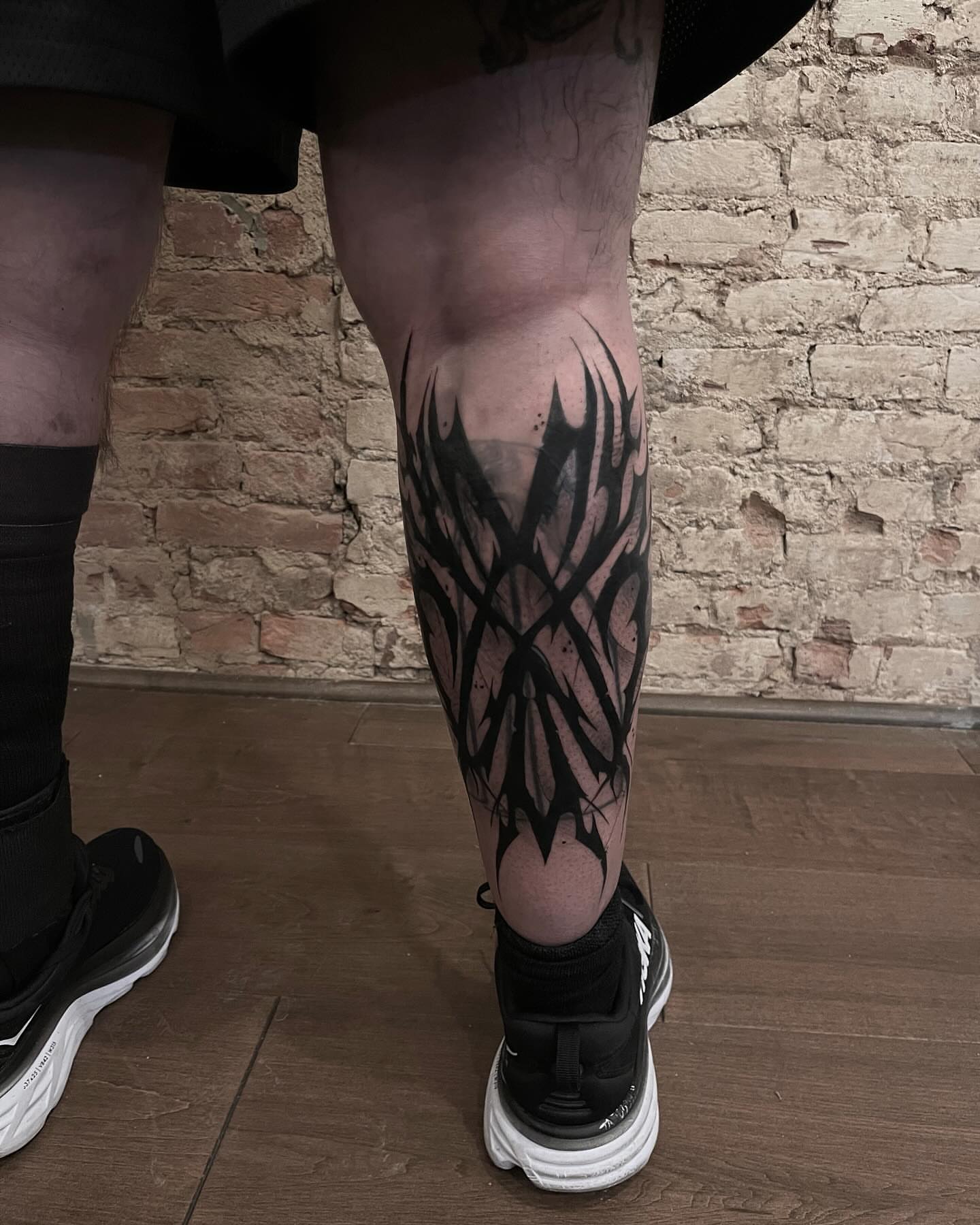 Abstract flame black and grey tattoo on the calf by Turk