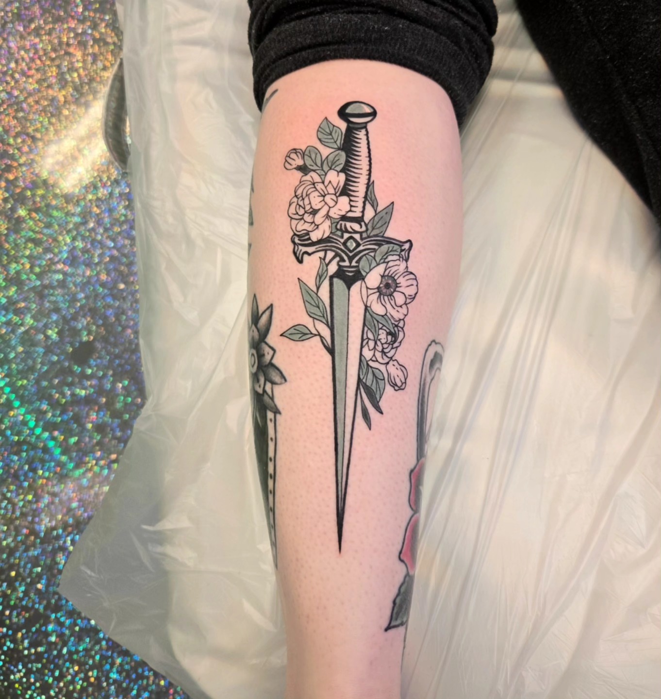 Sword and flowers American traditional tattoo on the forearm by Jake Lee