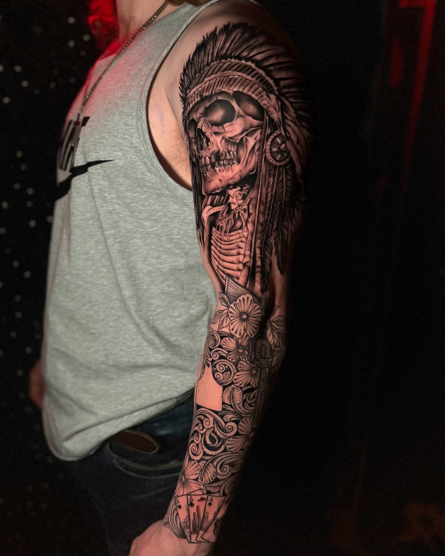 Skull with headdress realism tattoo on the upper arm by Tattoo Artist