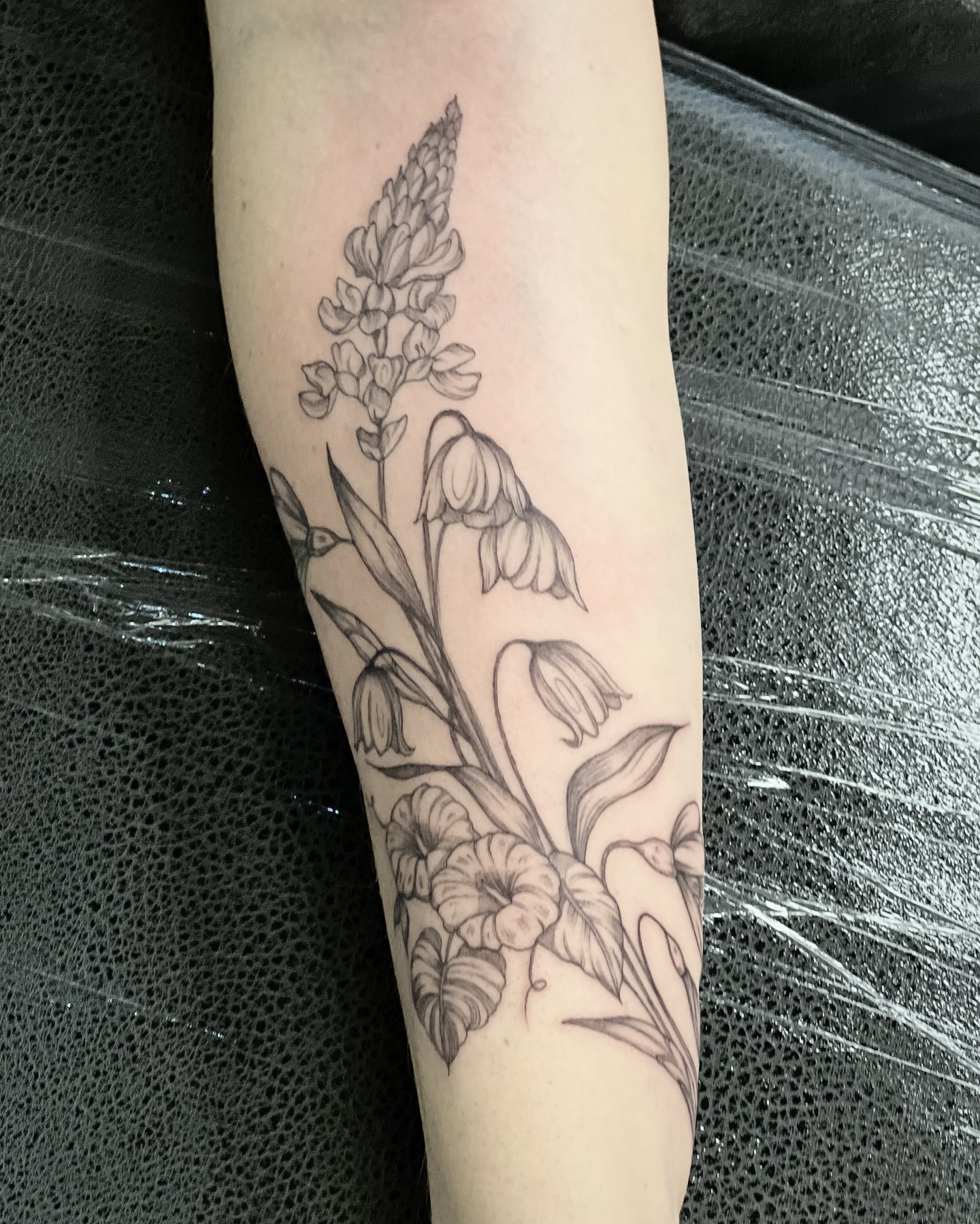 Floral arrangement black and grey tattoo on the forearm by Seraphim