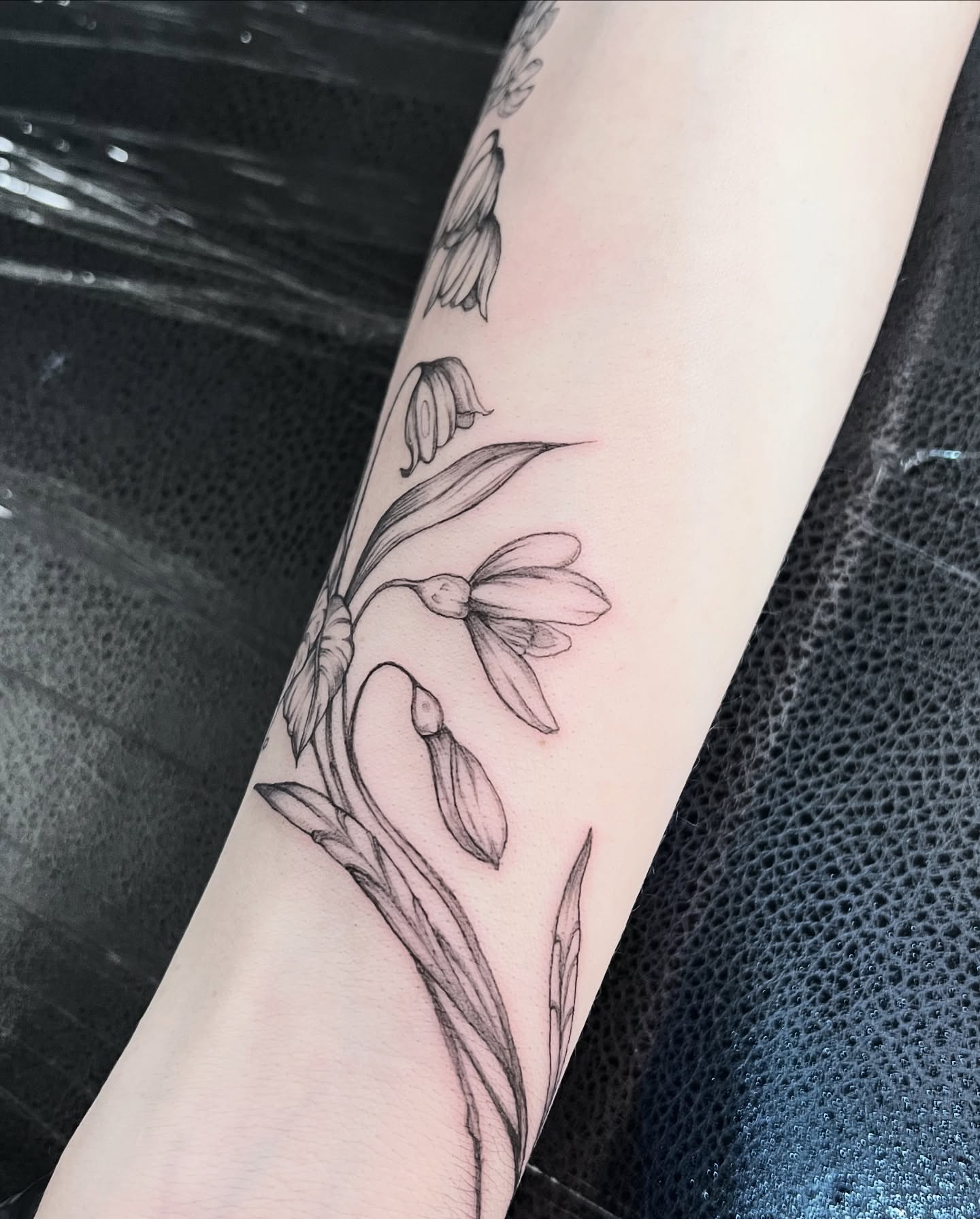 Snowdrops black and grey tattoo on the forearm by Seraphim