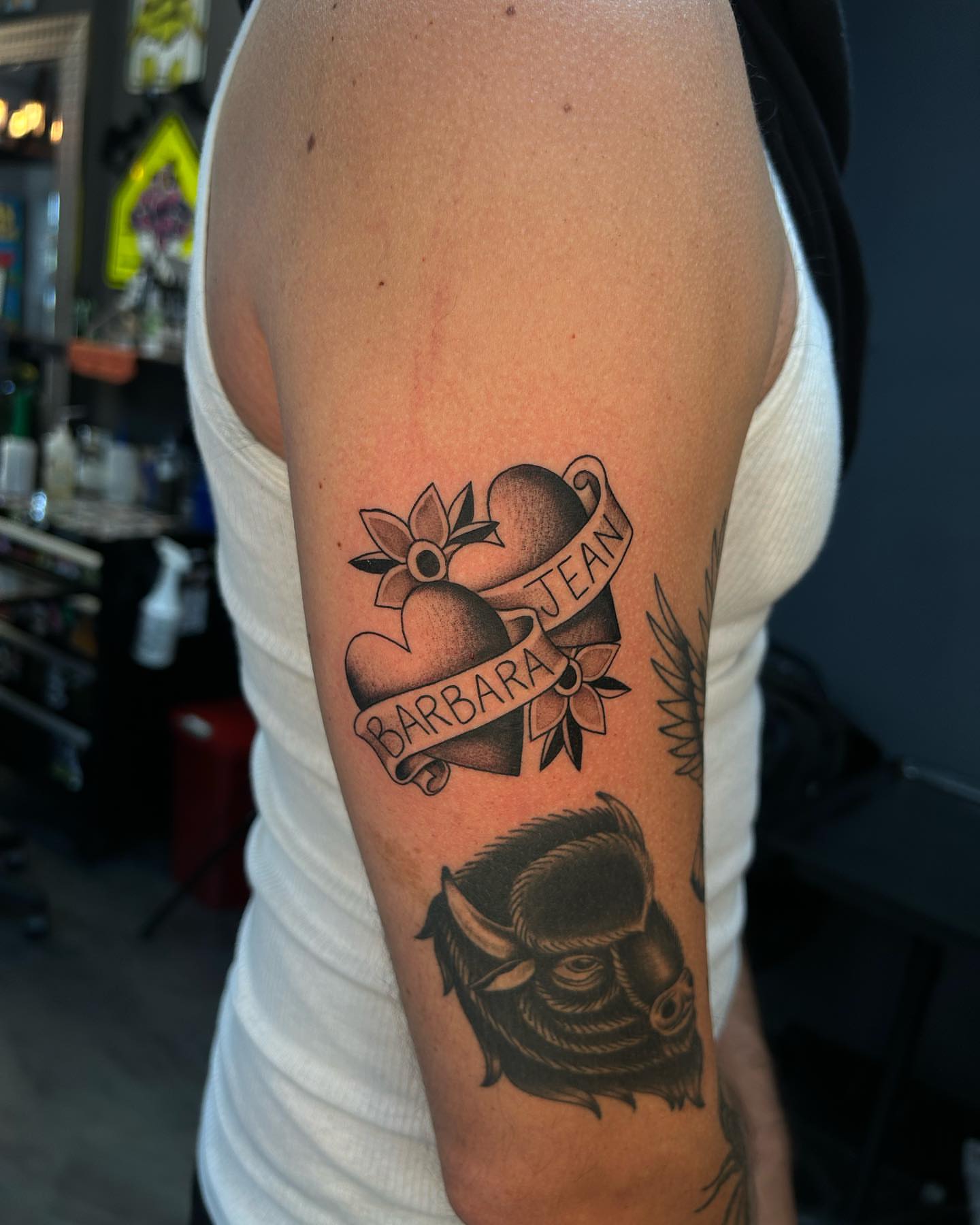 Hearts and name American traditional tattoo on the forearm by Lexi Kniskern