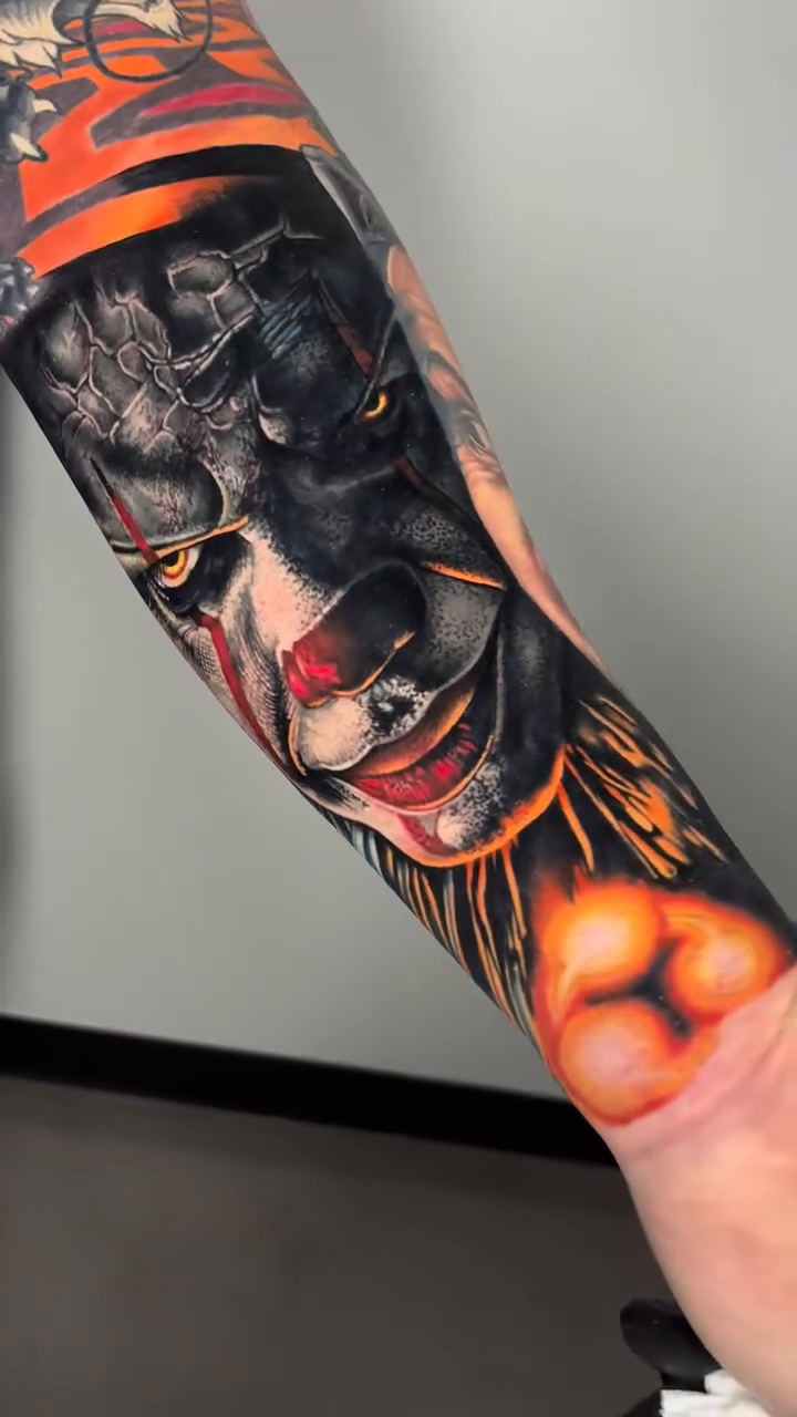 Clown face with fiery background realism tattoo by Jon Ronzka