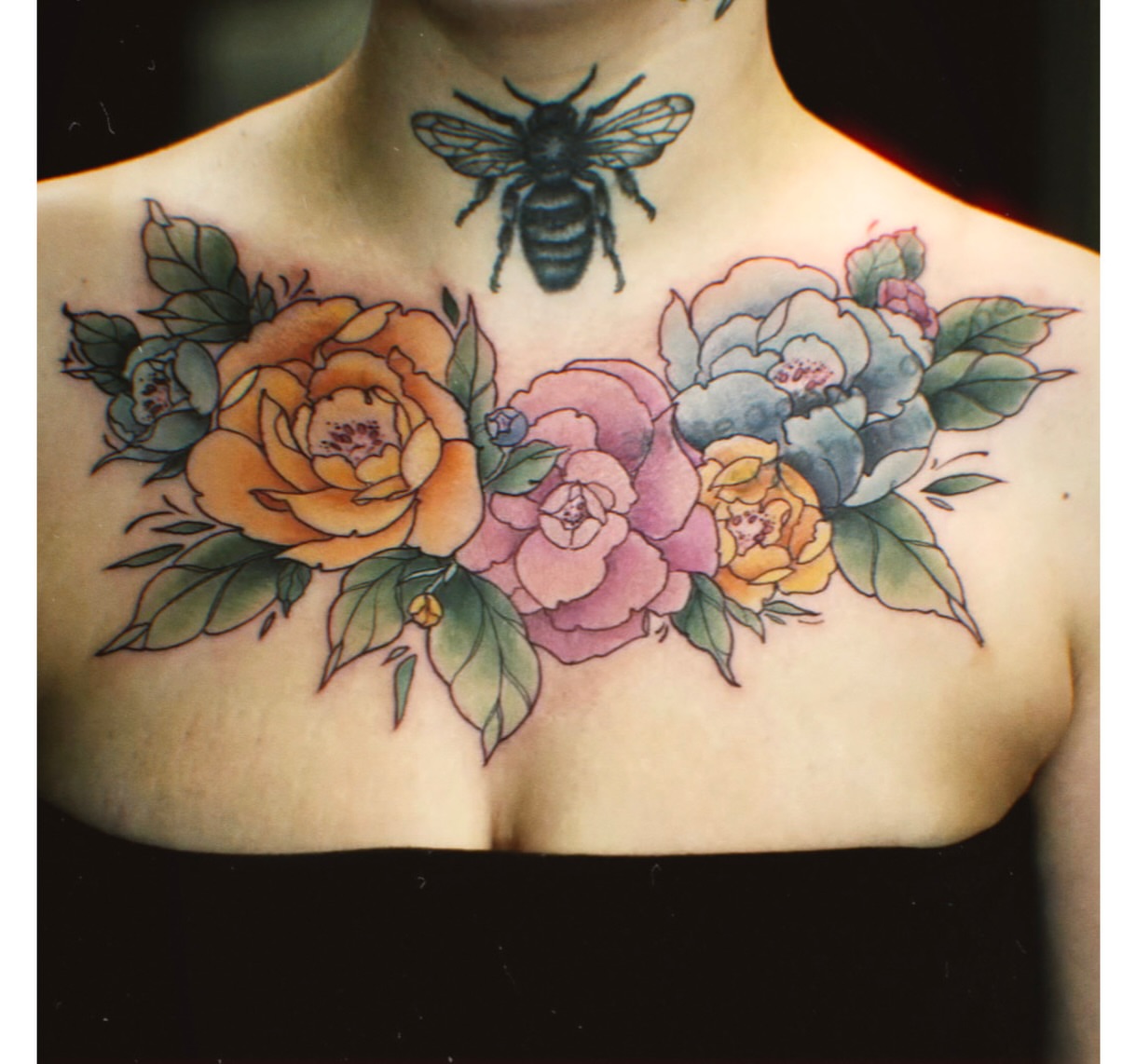 Floral bouquet watercolor tattoo on the chest by Jamie Clinton