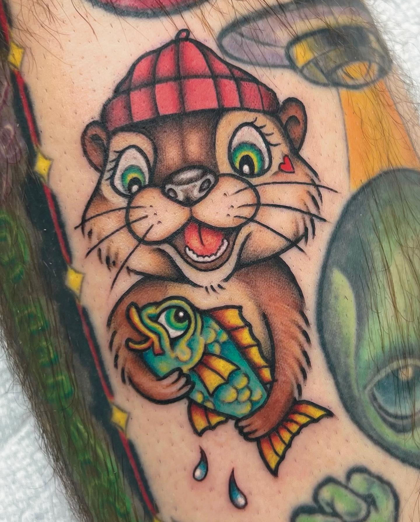 Otter holding fish American traditional tattoo on the forearm by Carson Smith, Chandler, Arizona