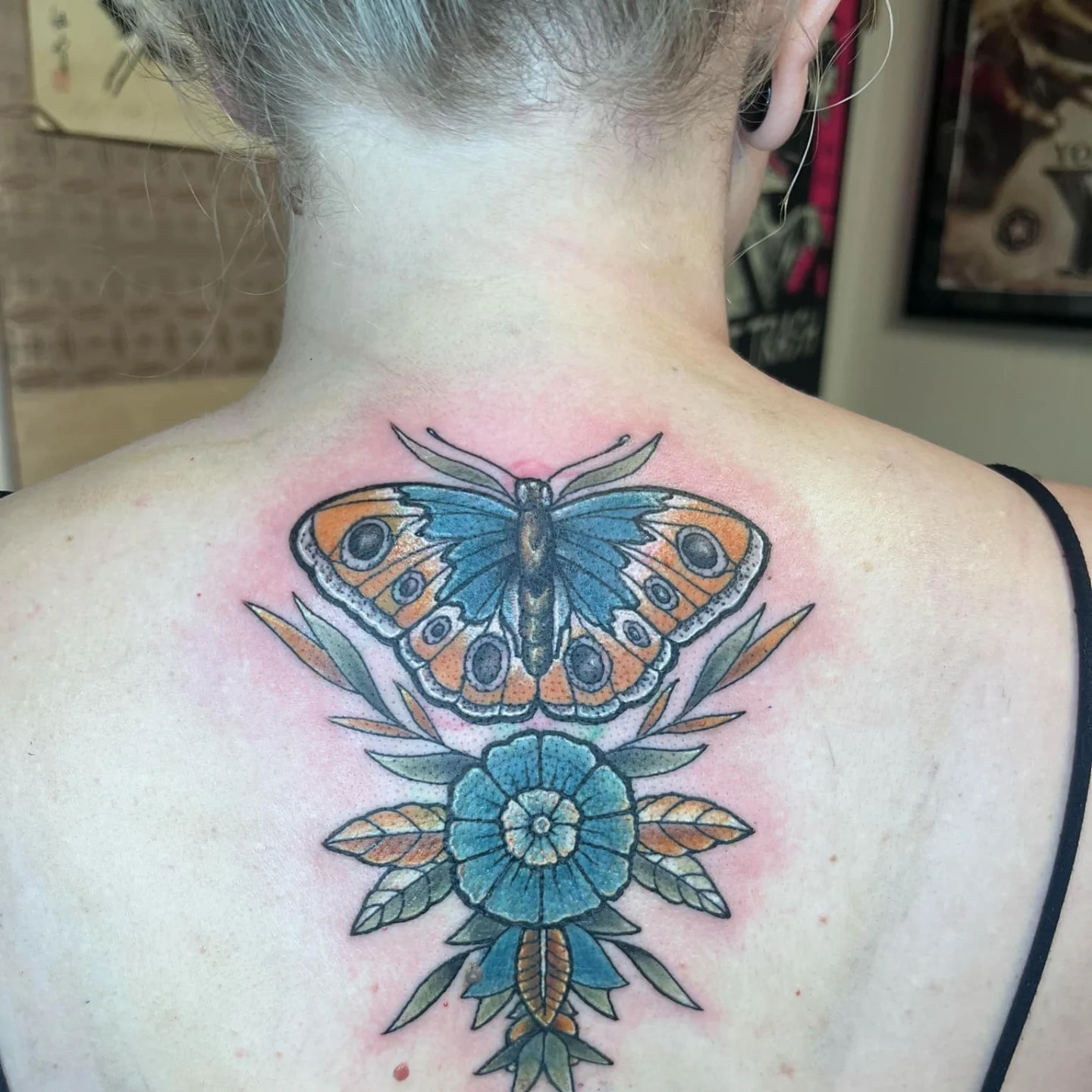Butterfly and flower new school tattoo on the back by Nason Dilts