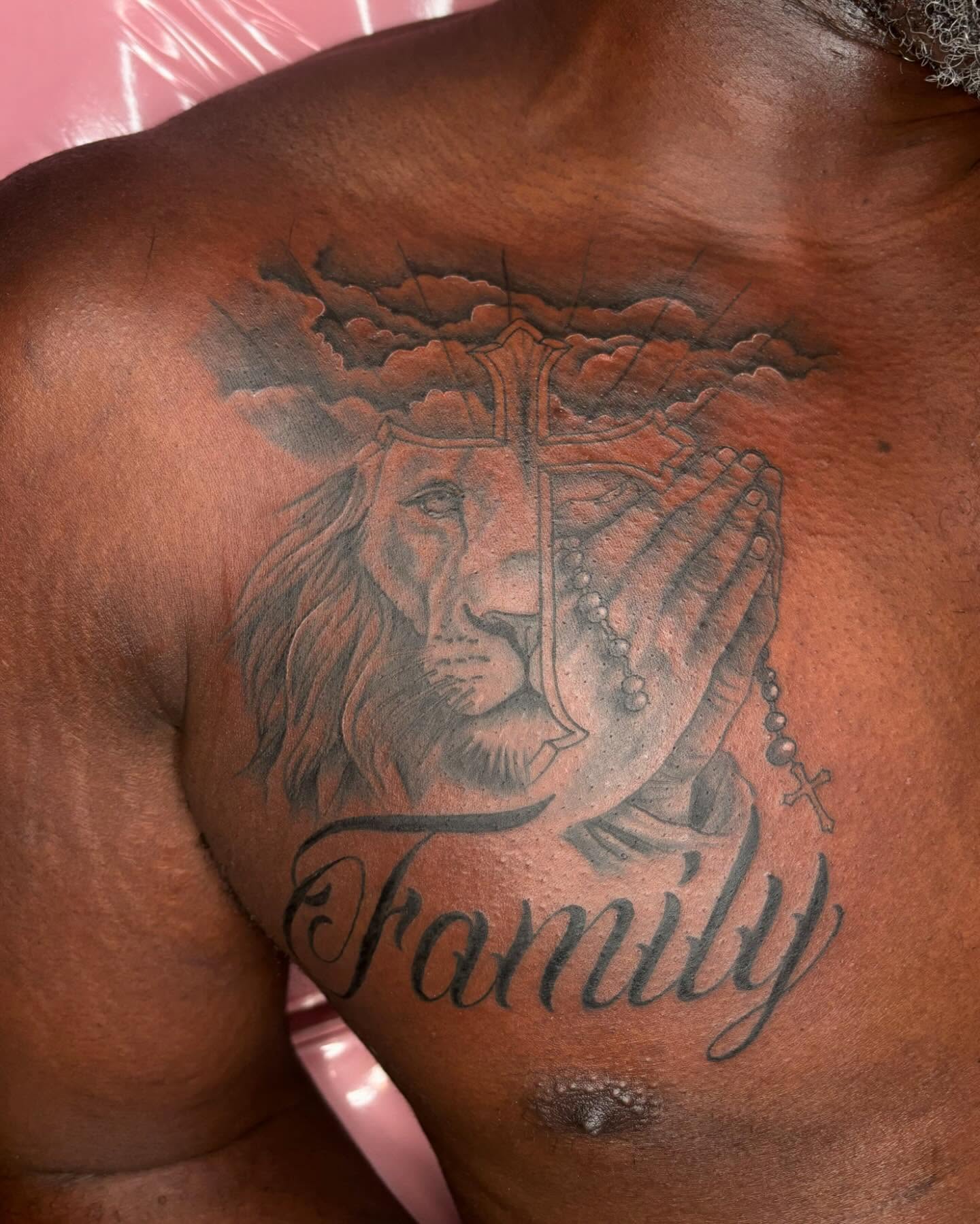 Lion and rosary black and grey tattoo on the chest by Pretty Naasty Ink🖤
